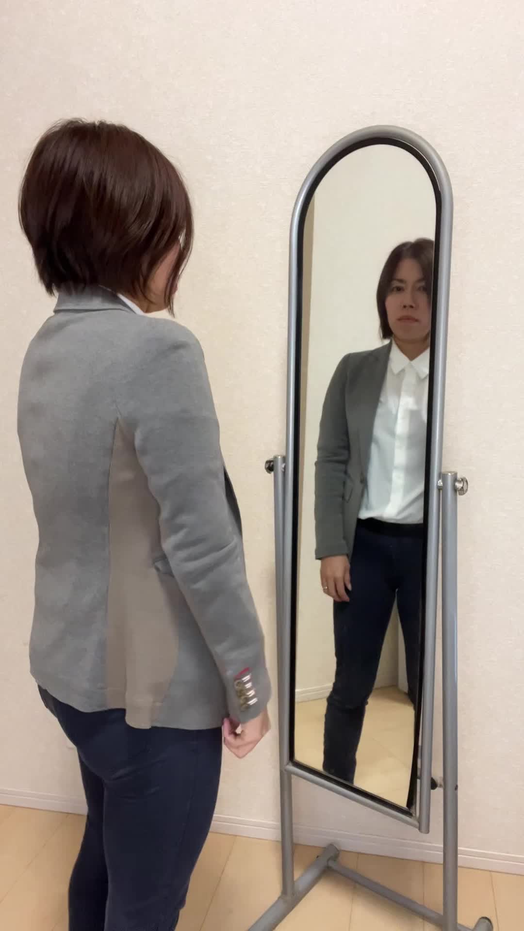 鏡の前でポケットから小銭を取り出し、それを手のひらでじっと眺める様子