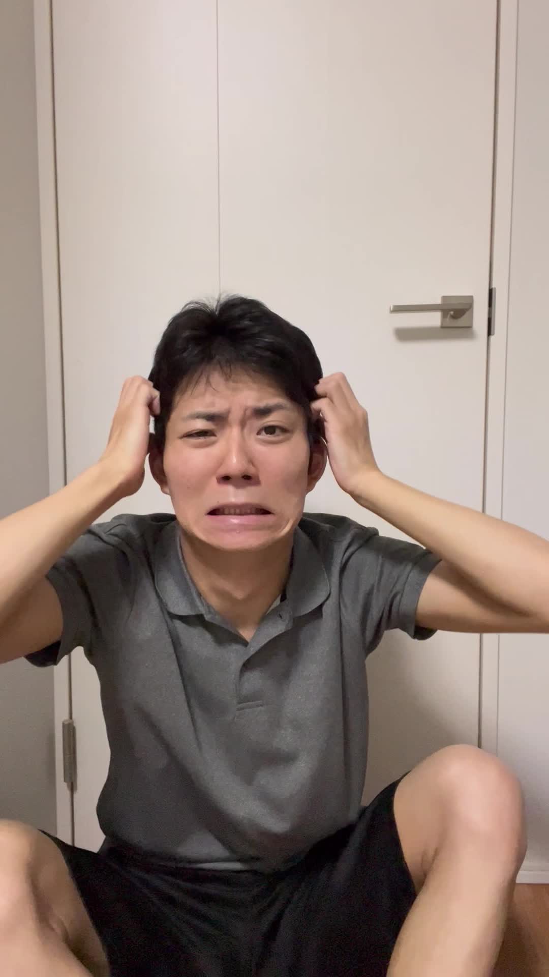 床に座り込み、髪のうねりを手で押さえ、「これじゃ外に出られない」と悩む様子