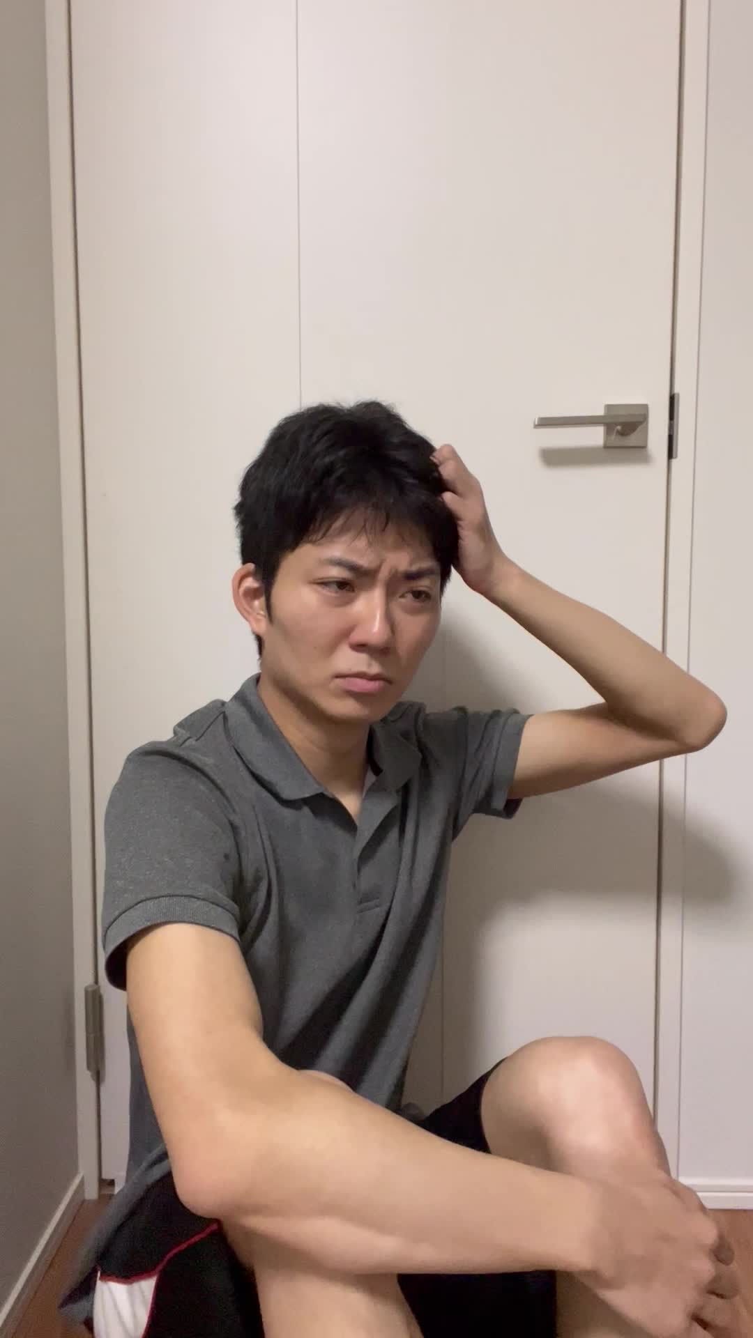 床で膝を立てて座り、「髪がまとまらなくて朝から大変」と困った様子を見せる仕草