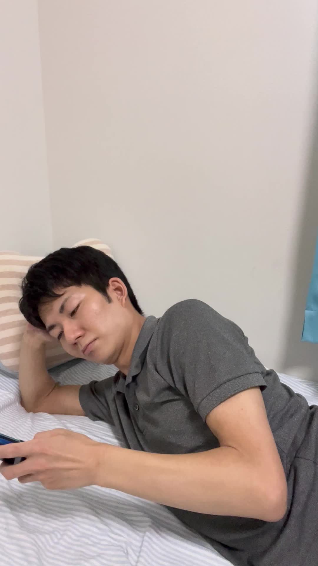 ベッドで横になり、スマホで「髪をサラサラにする方法」を検索している姿