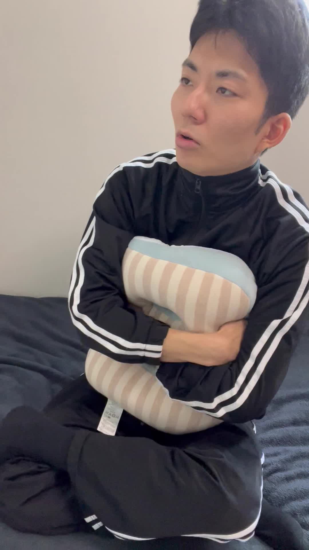 ベッドでクッションを抱きしめながら、「今日も連絡ないのかな」と少し落ち込む表情