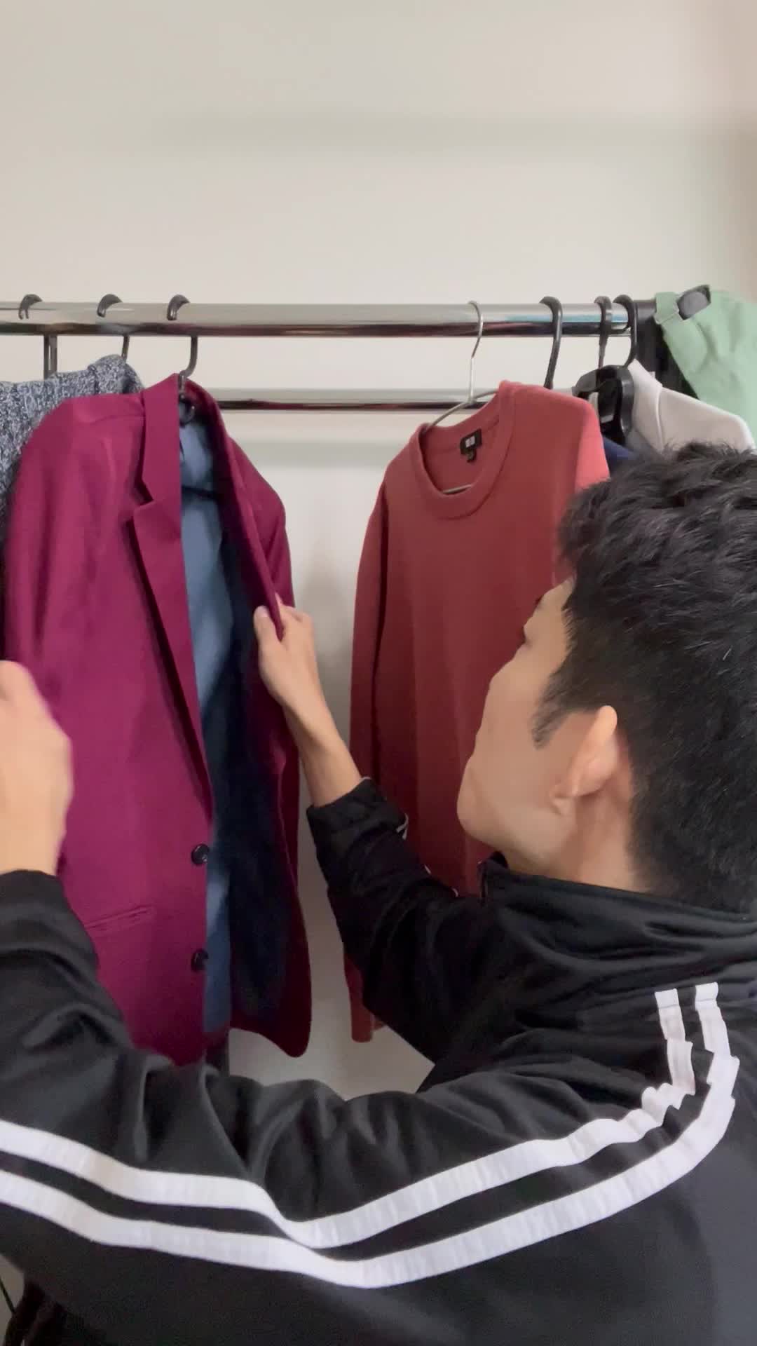 床に座り、クローゼットを開けてデート用の服を選びながら悩む仕草