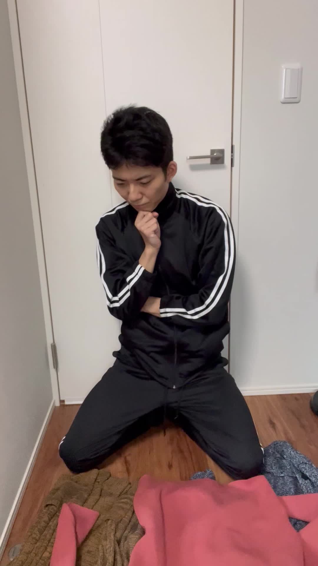 床に広げた服を一つずつ見比べ、「これが一番良さそう」と選ぶ決断の表情