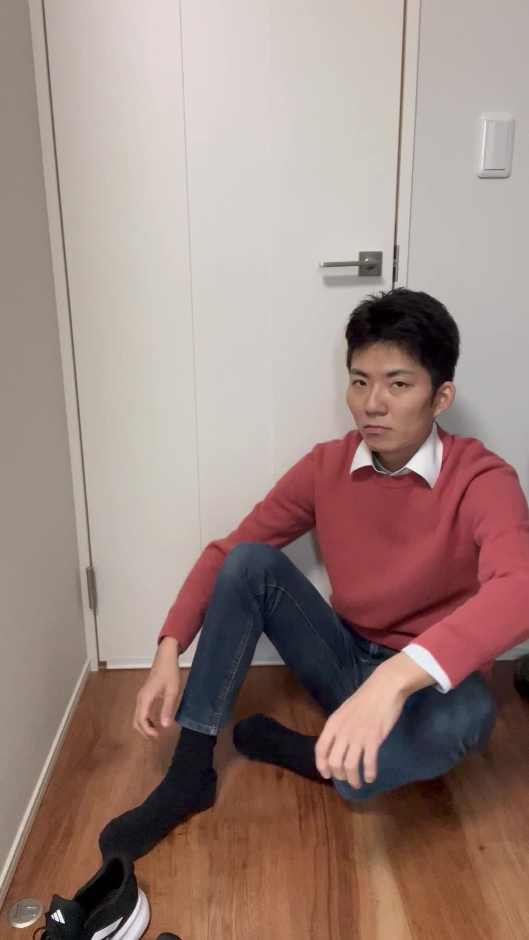 床で靴を履きながら、「時間に遅れないようにしなきゃ」と気を引き締める表情