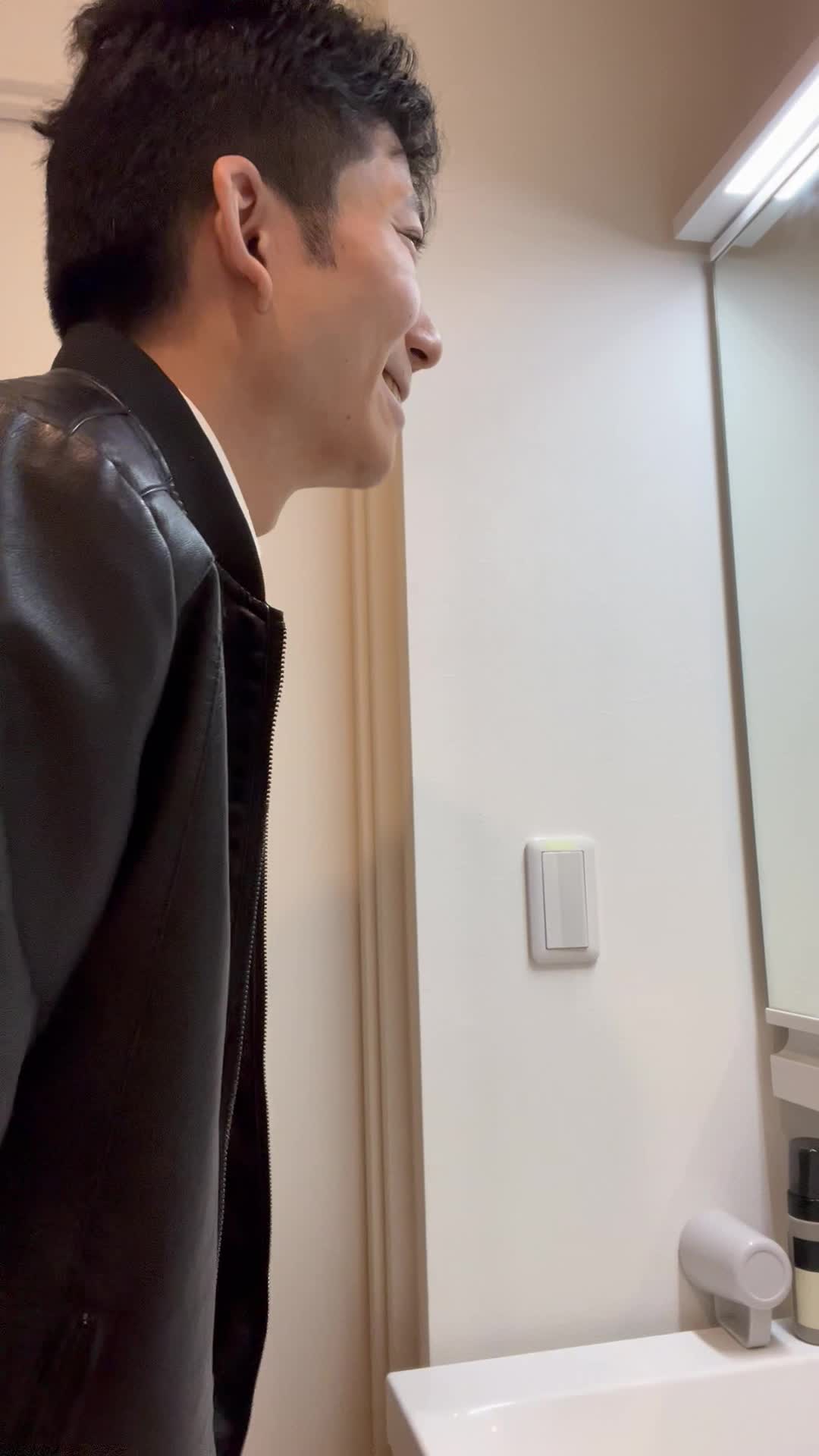 鏡越しに自分の笑顔を確認し、「今日のメイクはバッチリ」と頷く動作