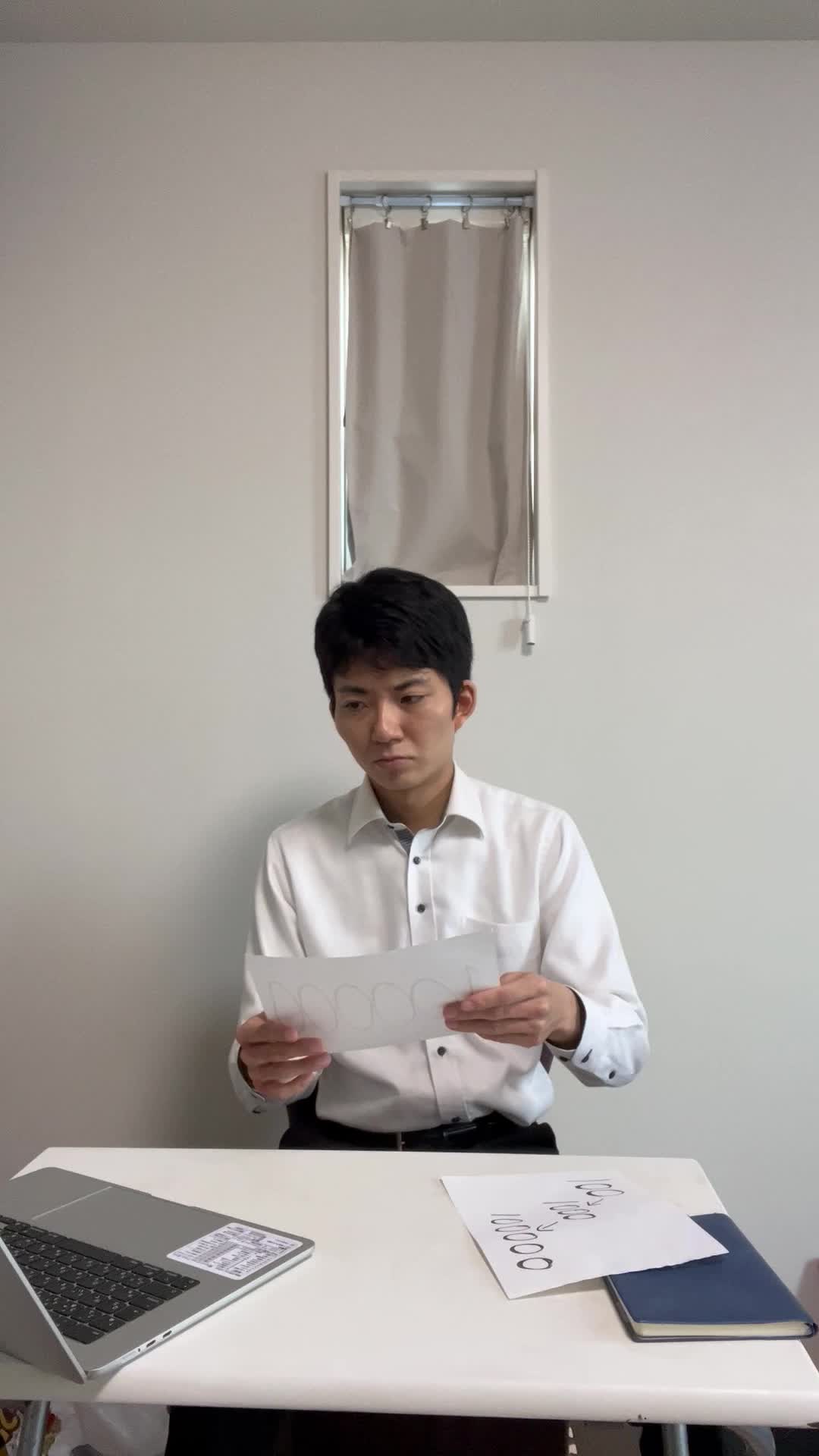 テーブルで資料を折りたたみ、胸ポケットにしまい「行動に移る」決意を表す仕草