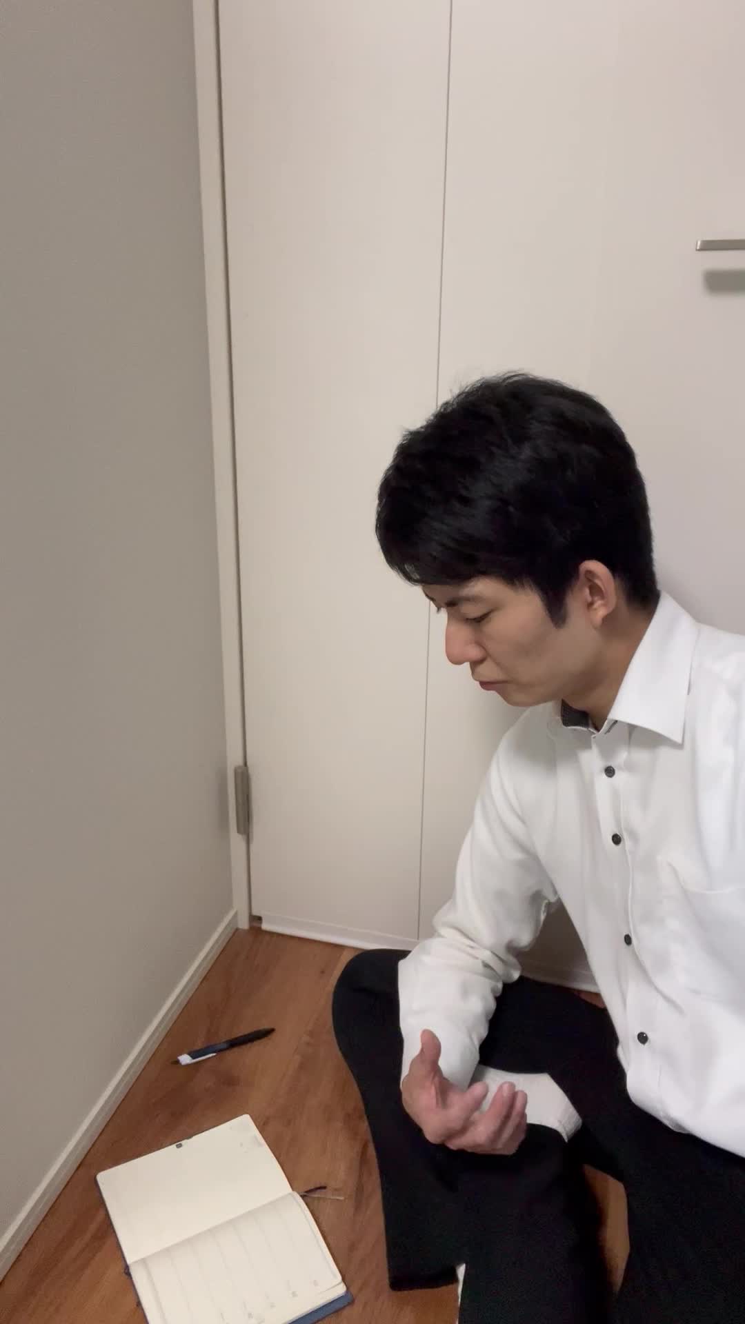 床にノートとペンを広げ、真剣に目標をリストアップする様子を映すシーン