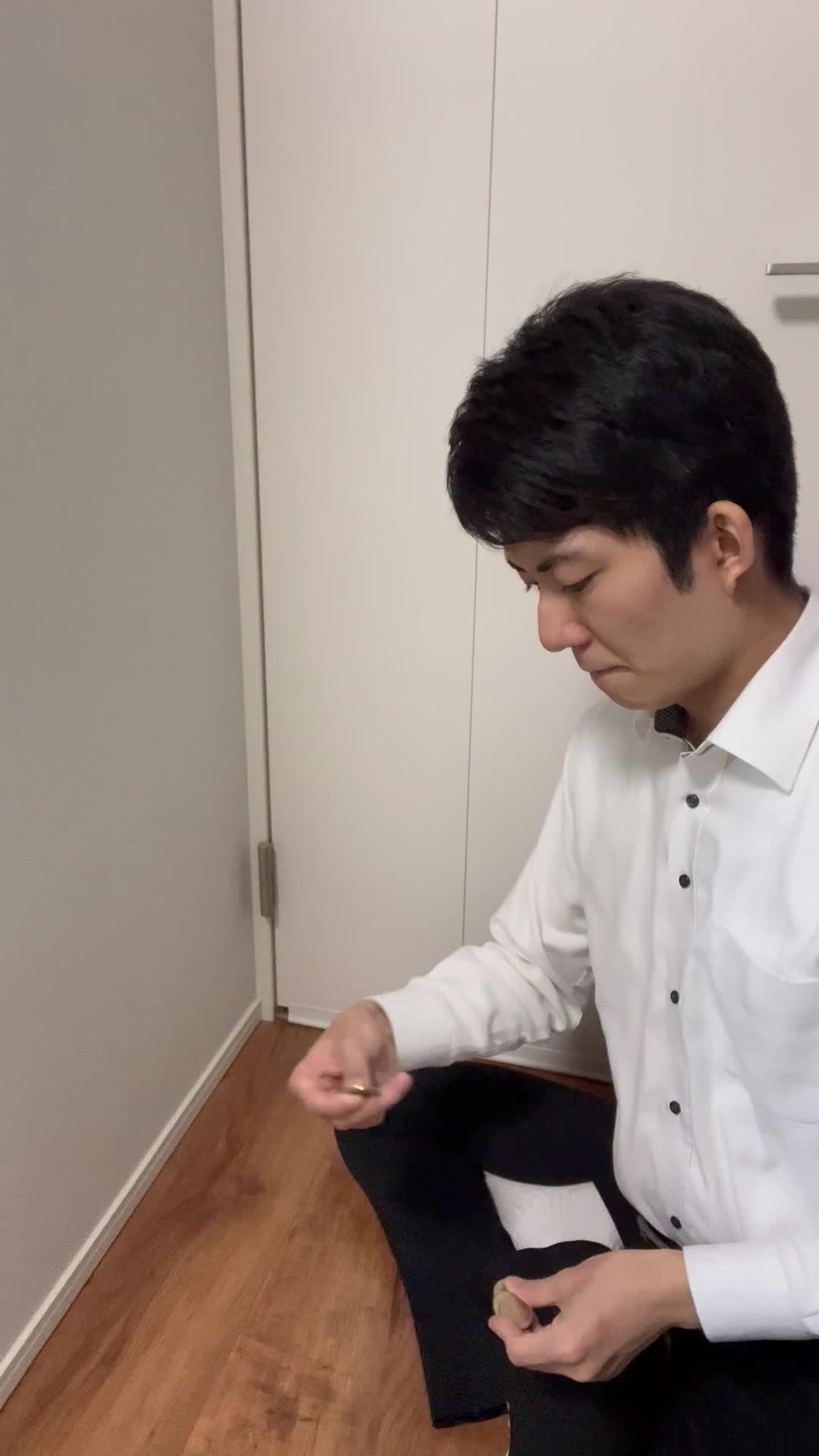 床でコインを一つ一つ並べ、「これが未来への投資だ」と納得する風の動作