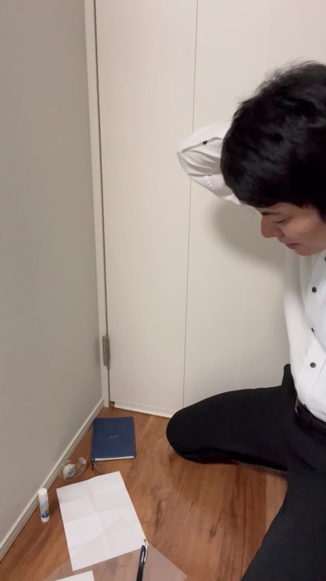 床に膝をつき、散らばった資料を必死に整理しながら何かを探す姿