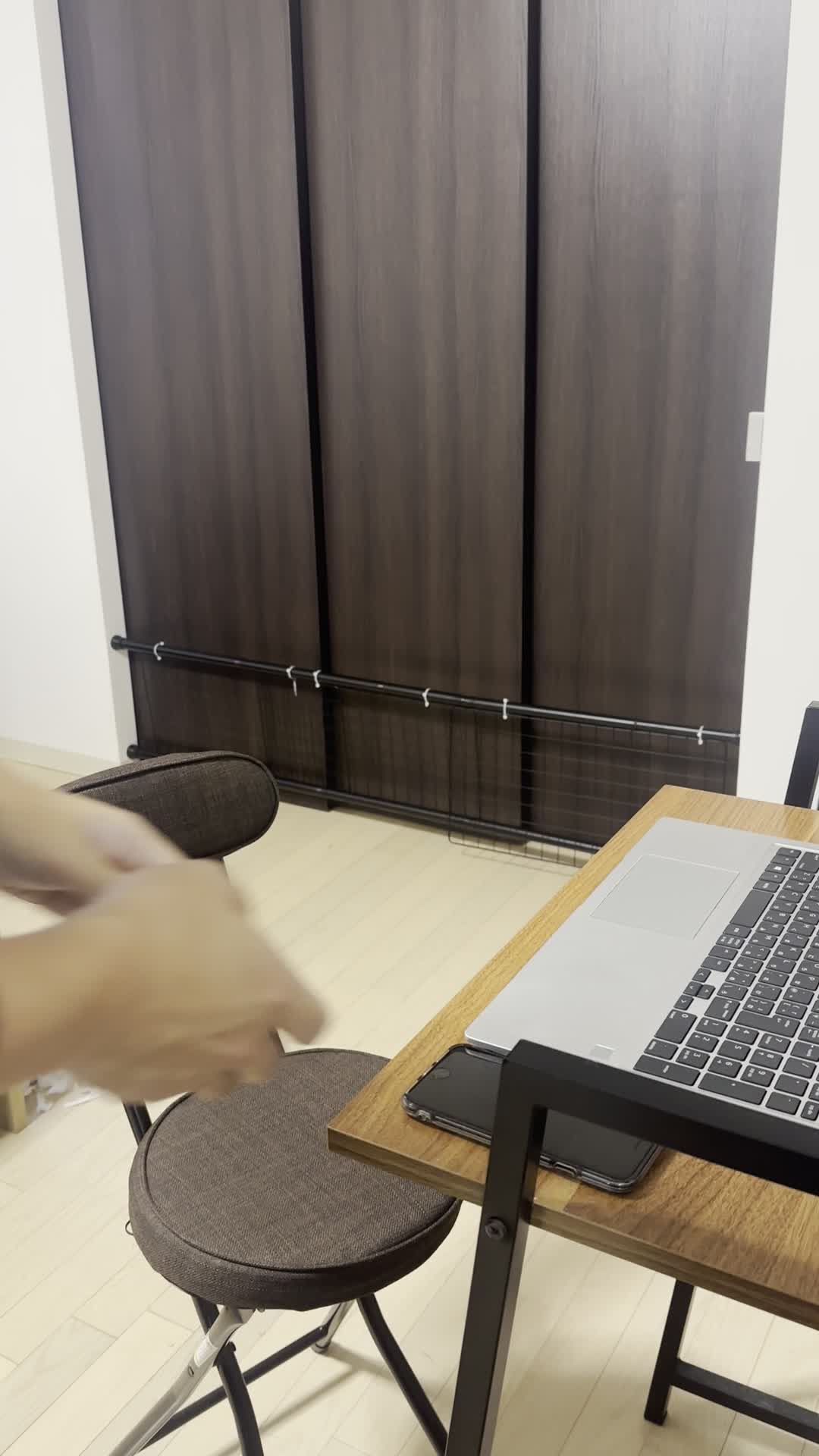 椅子に腰掛け、スマホのメッセージをじっと見つめて微笑むシーン