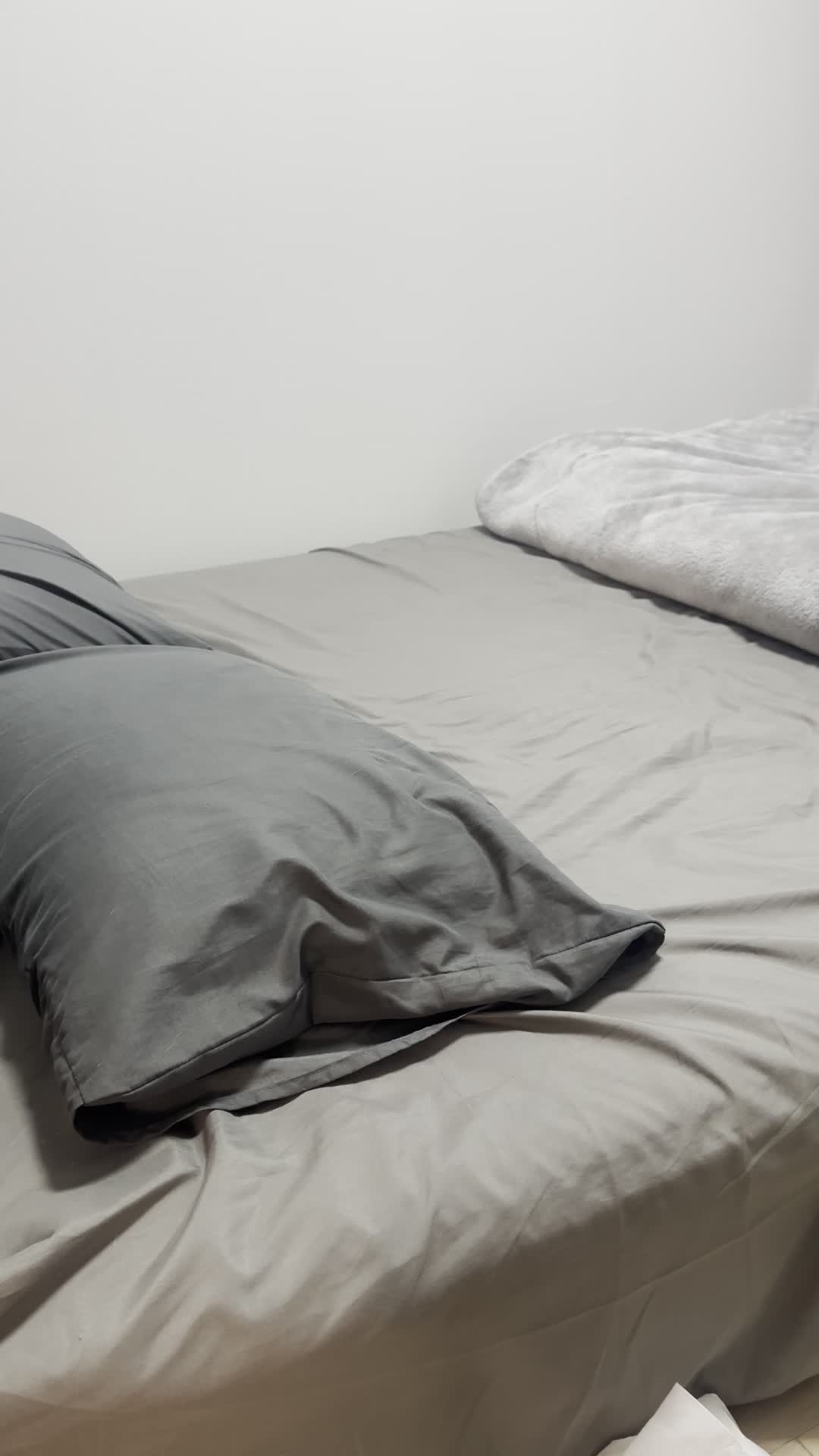 ベッドで横になり、スマホを見ながら「次に何を送ろう？」と考え込む動作