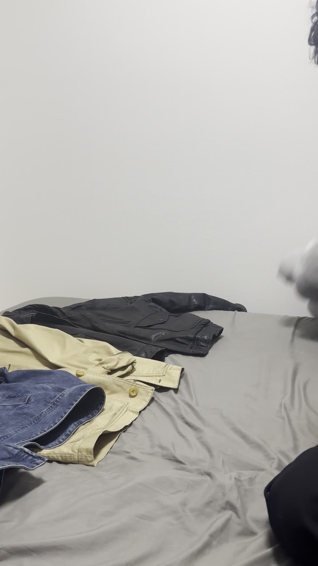 床に広げた服を一つずつ見比べ、「これが一番良さそう」と選ぶ決断の表情