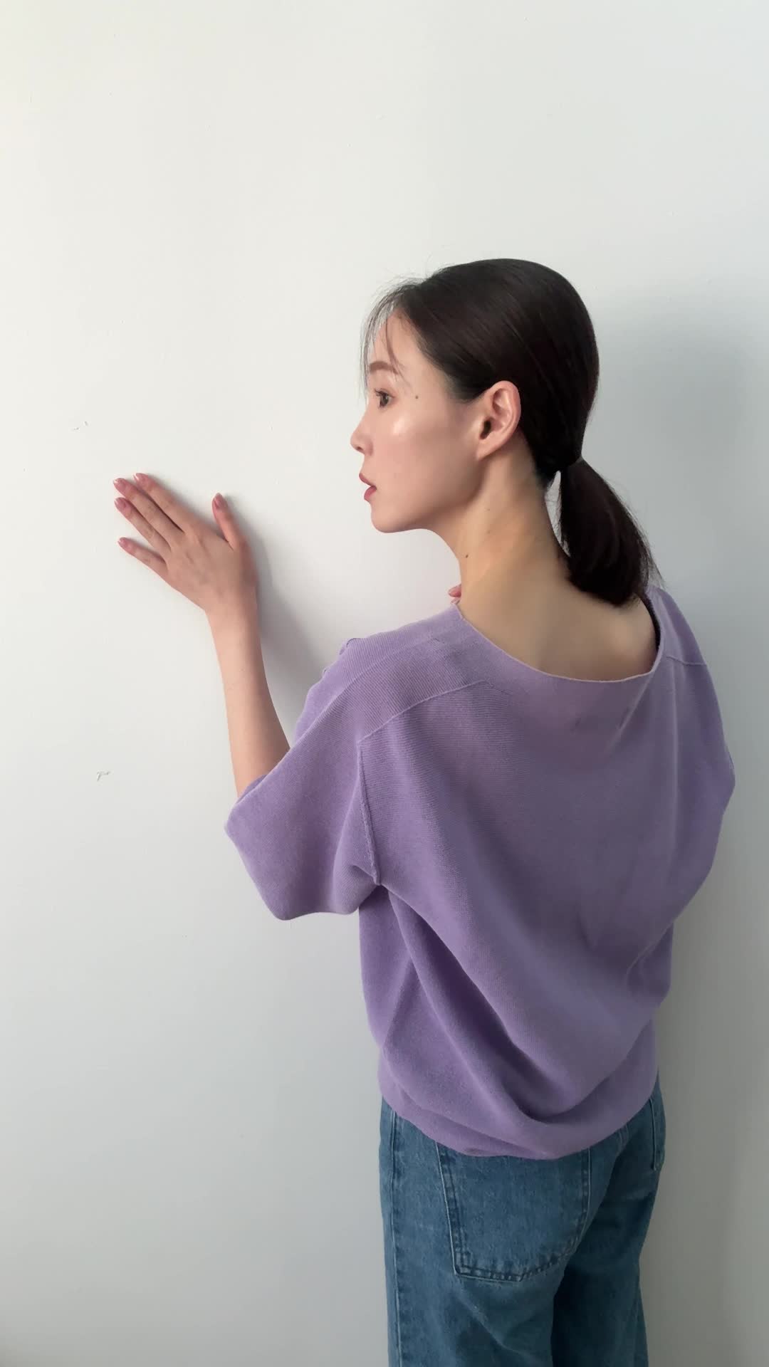 壁に近づいて手で触れ、じっと観察するような動作