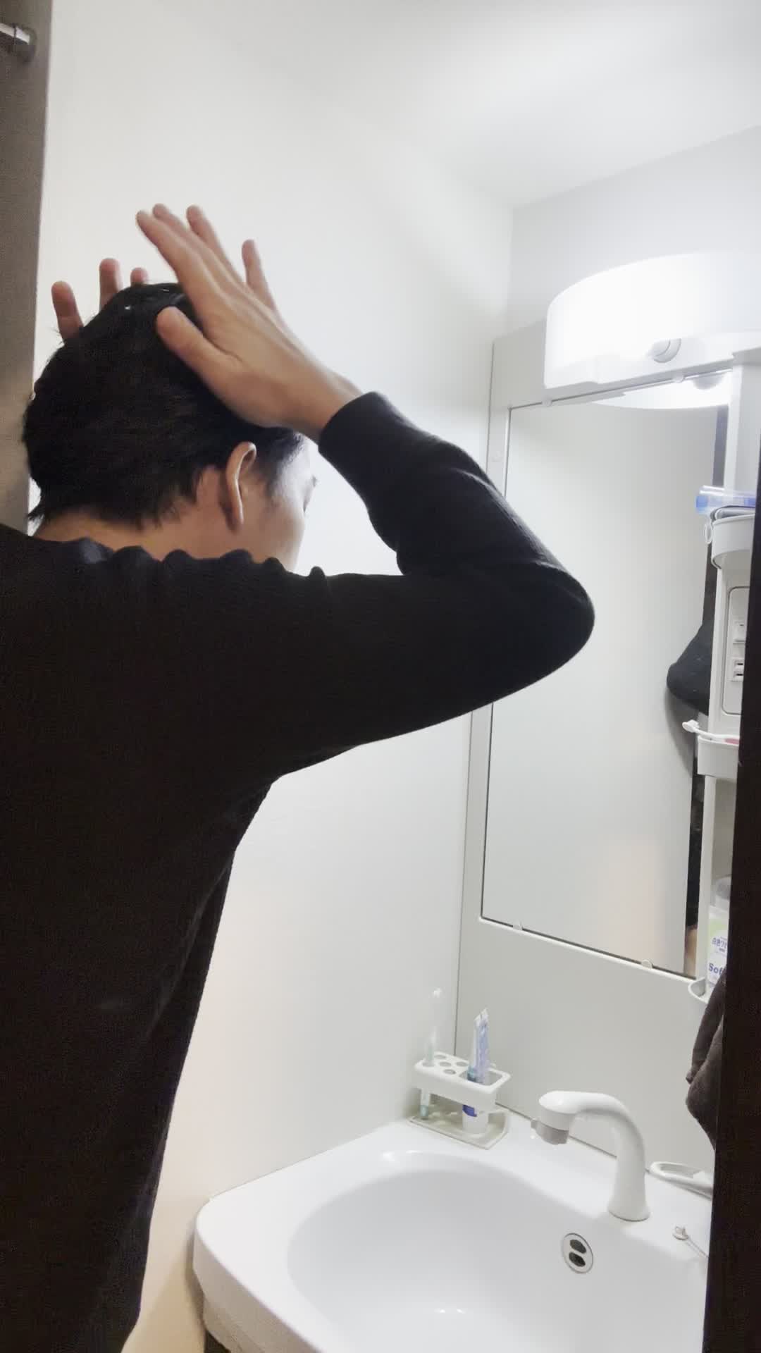 鏡の前で髪を触りながら、「この広がりをどうにかしたい」と悩む姿