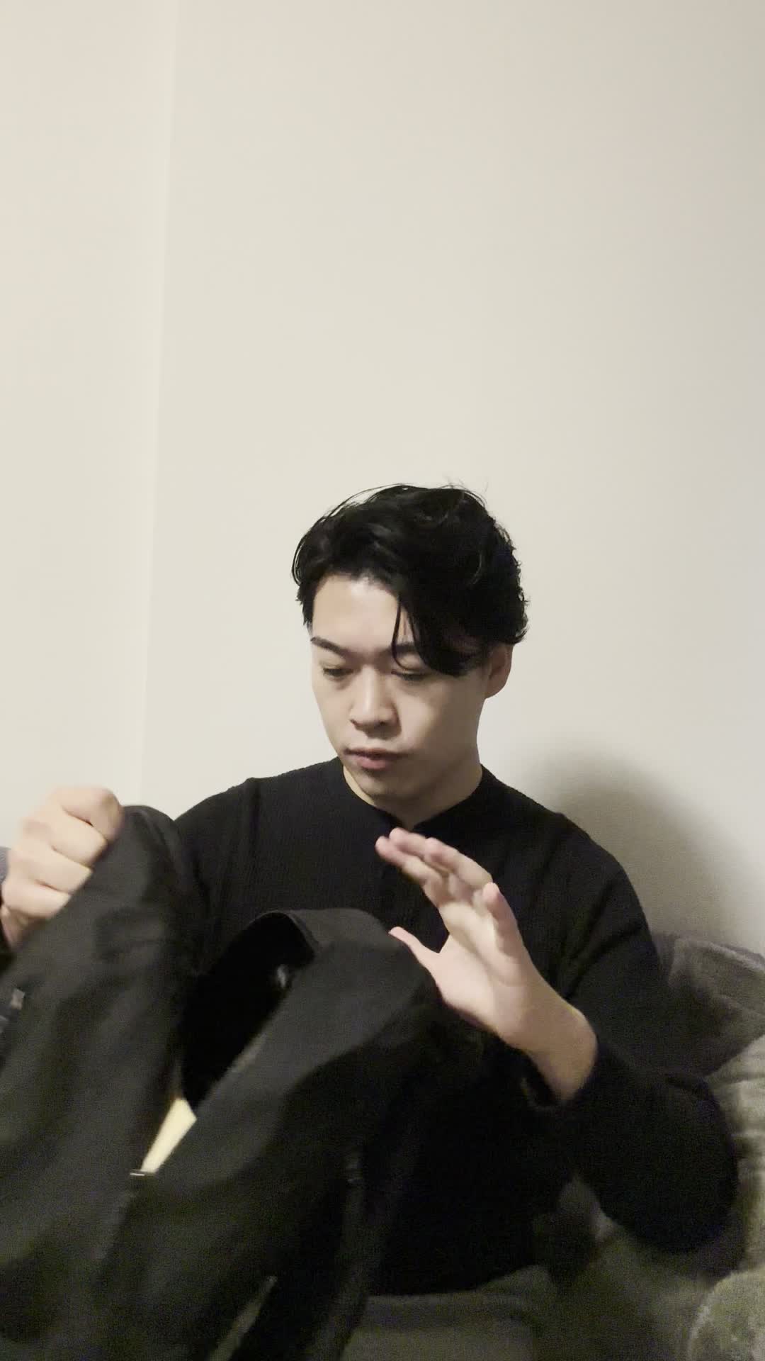 ソファでカバンを開けて、「ヘアケアアイテムが必要だな」と確認する動作