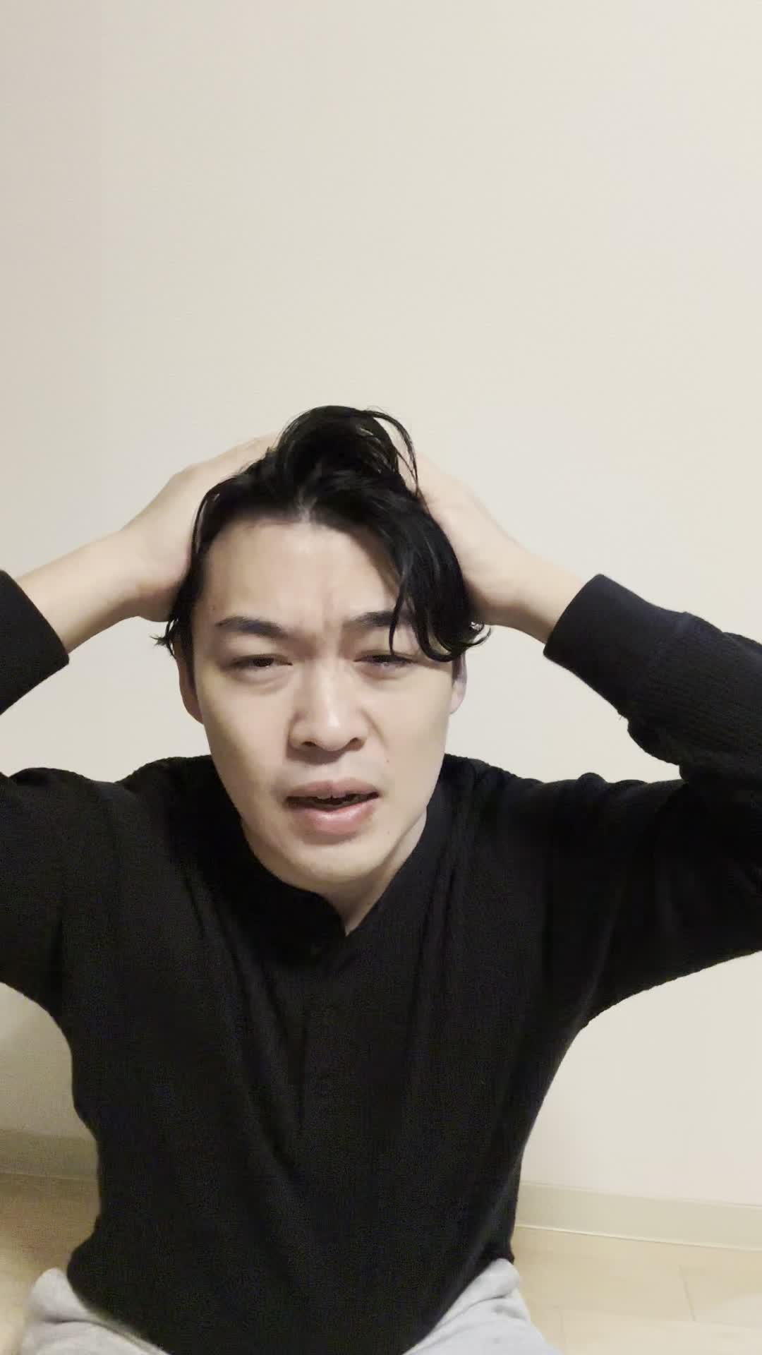 床に座り込み、髪のうねりを手で押さえ、「これじゃ外に出られない」と悩む様子