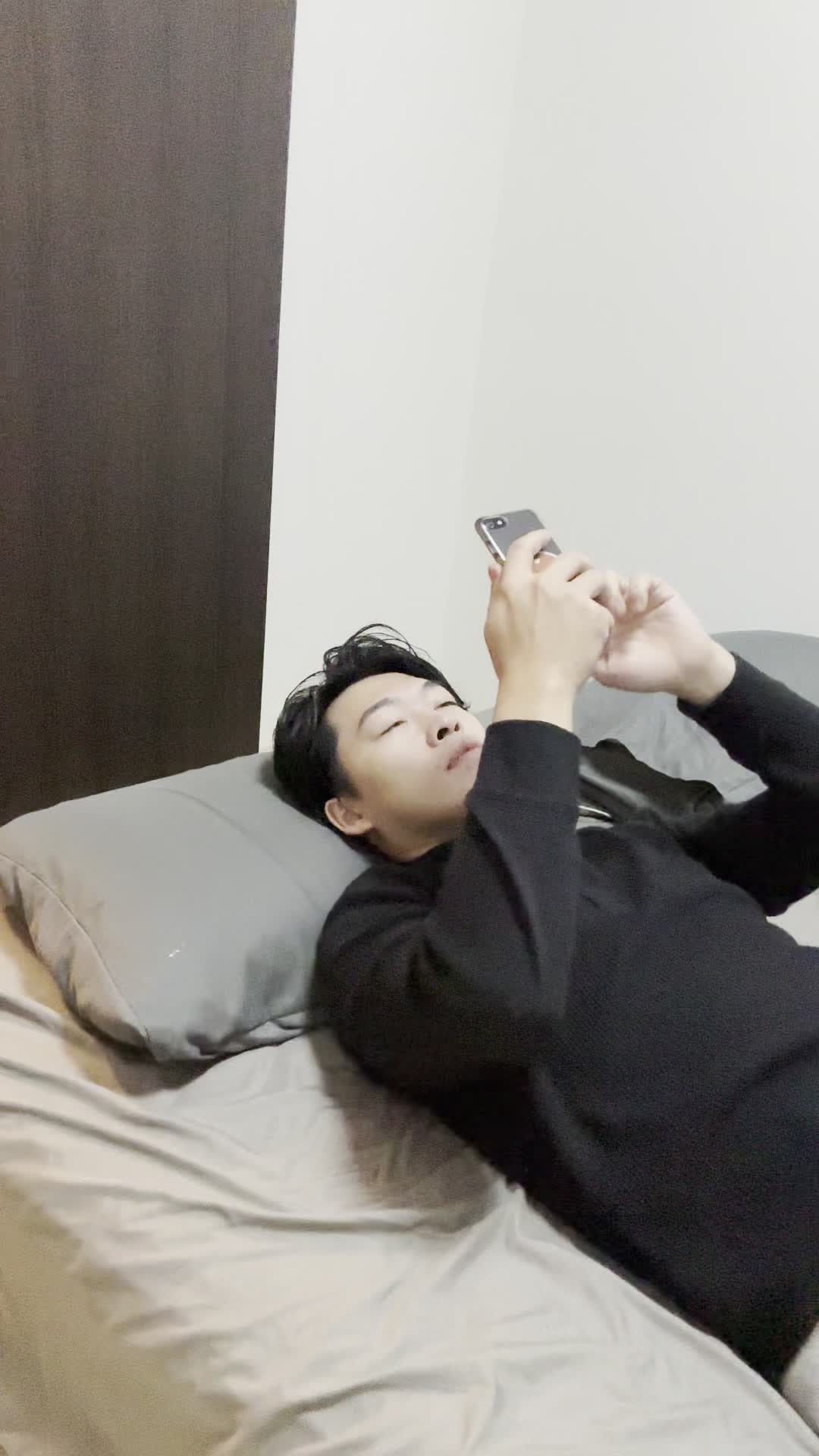 ベッドで横になり、スマホで「髪をサラサラにする方法」を検索している姿