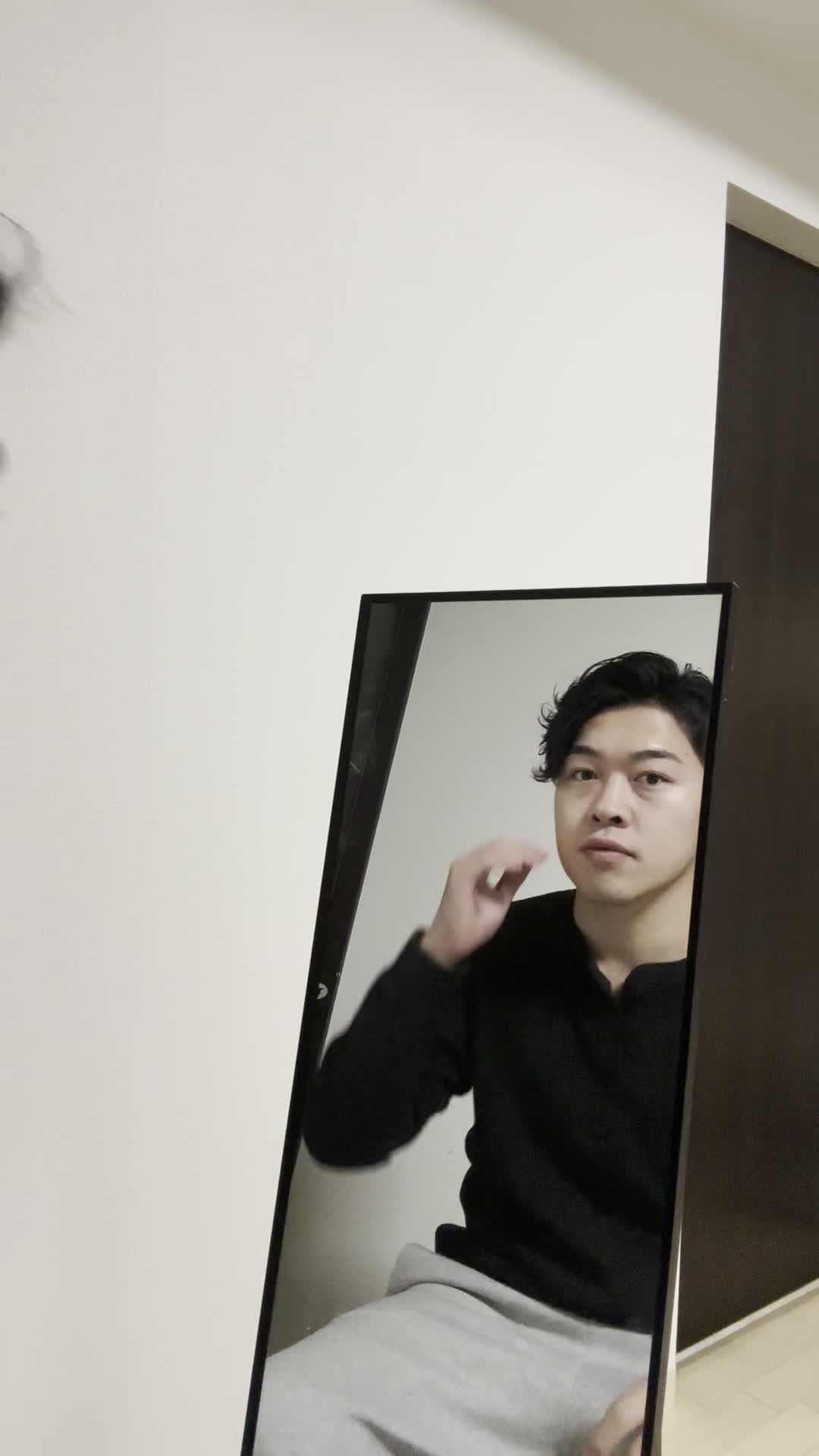 鏡越しに目の下を軽く押さえ、「これが解決したら毎朝楽かも」と期待する動作