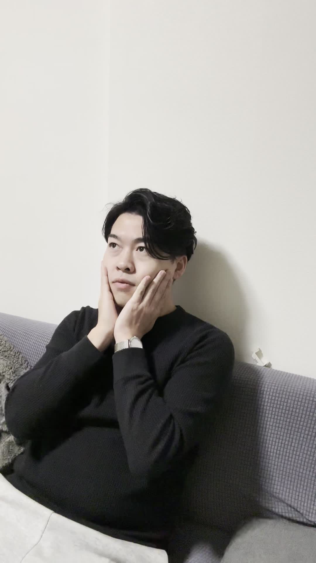 ソファで手を頬に当て、「小顔になったら髪型も変えられるかも」と考える仕草