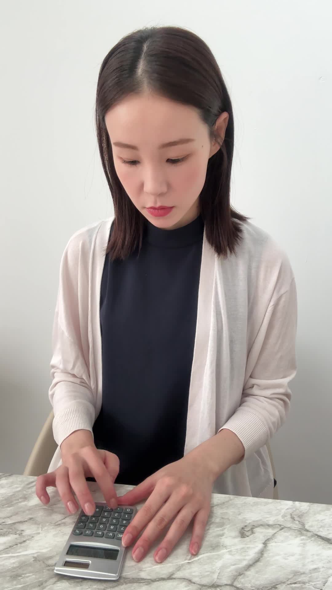 テーブルで電卓を叩き、「この保険料なら払えるかな」と計算する動作