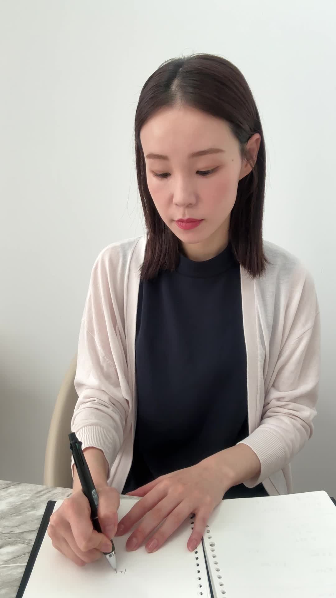 テーブルでノートに書きながら考える真剣な姿