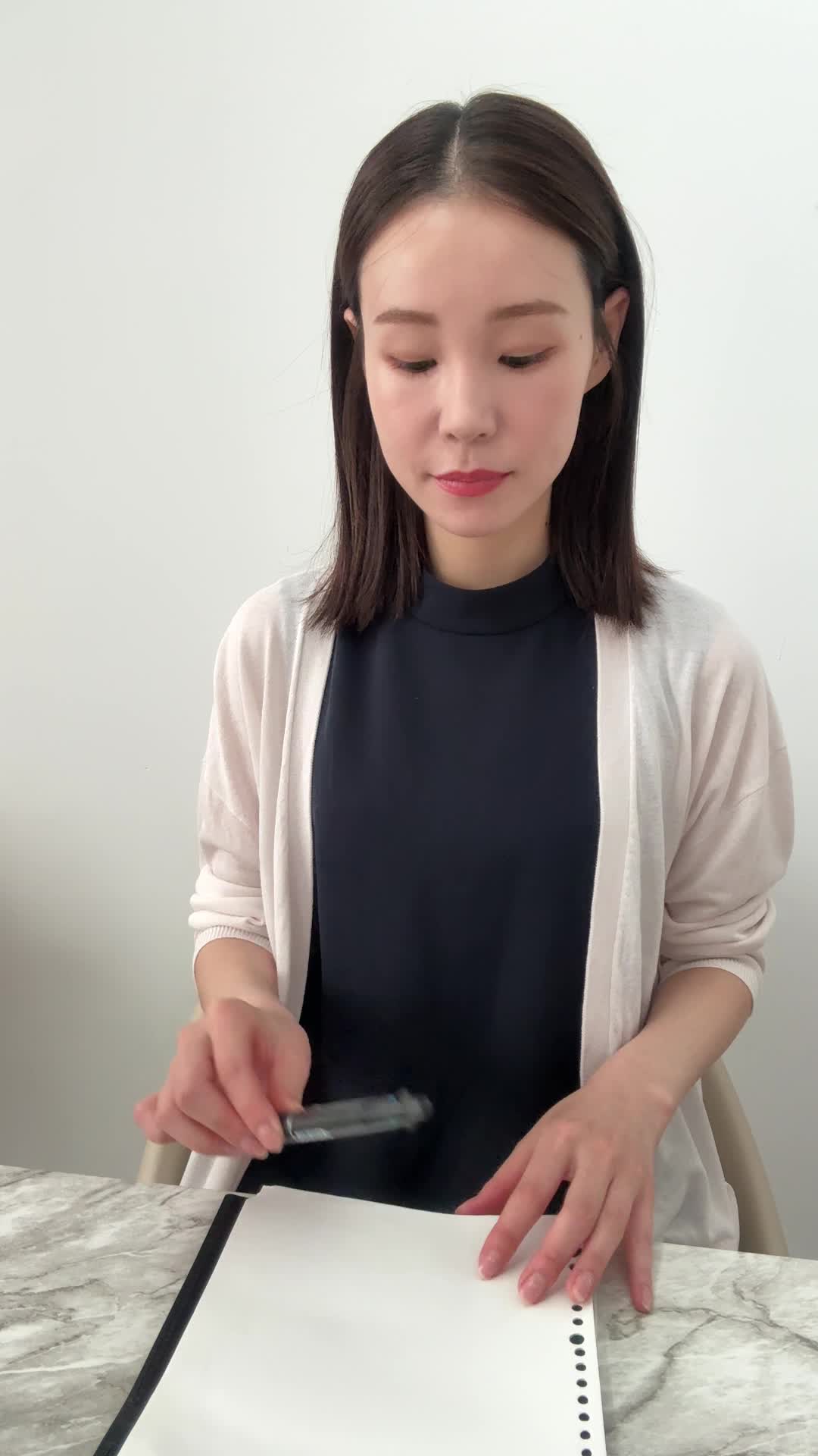 テーブルでペンを置き、「これで家族の安心が得られる」と納得した表情