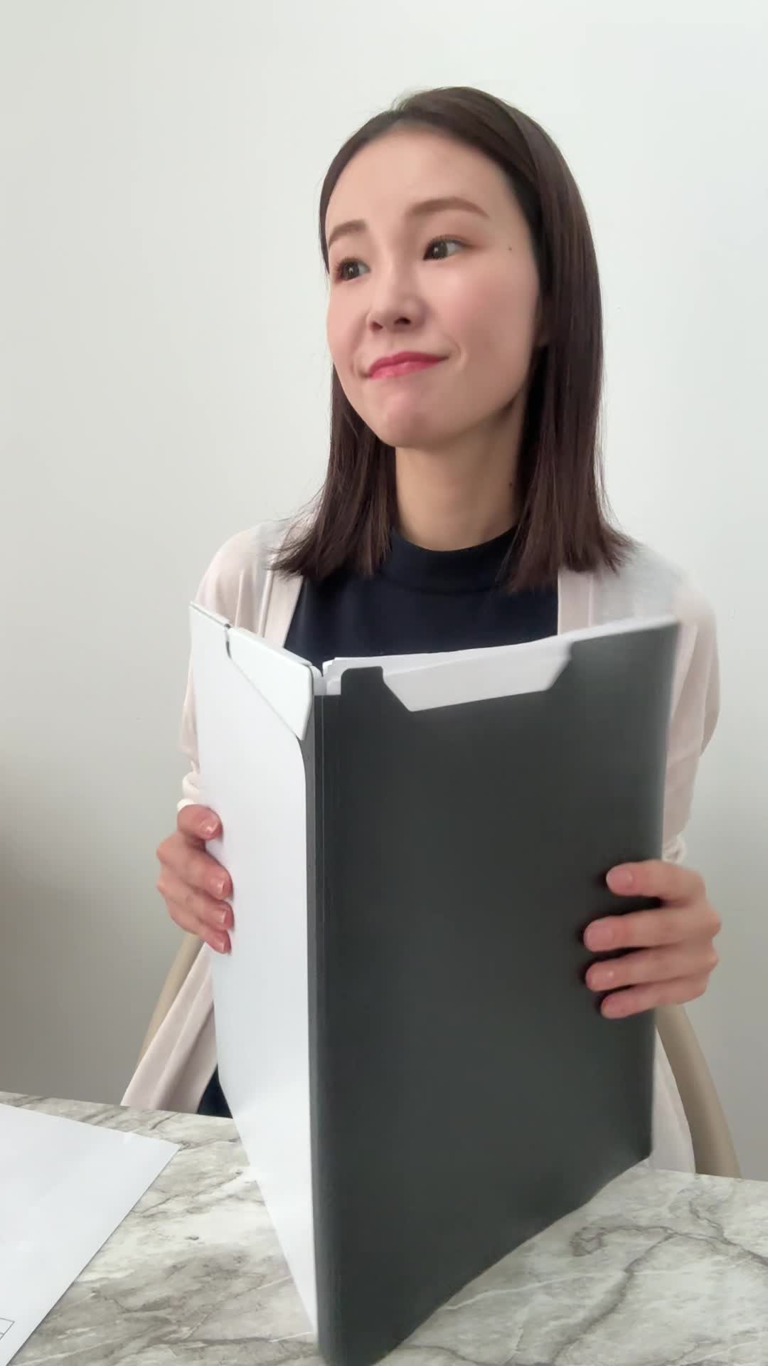 テーブルに広げた書類をまとめながら、「これで決まりかな」と満足する姿