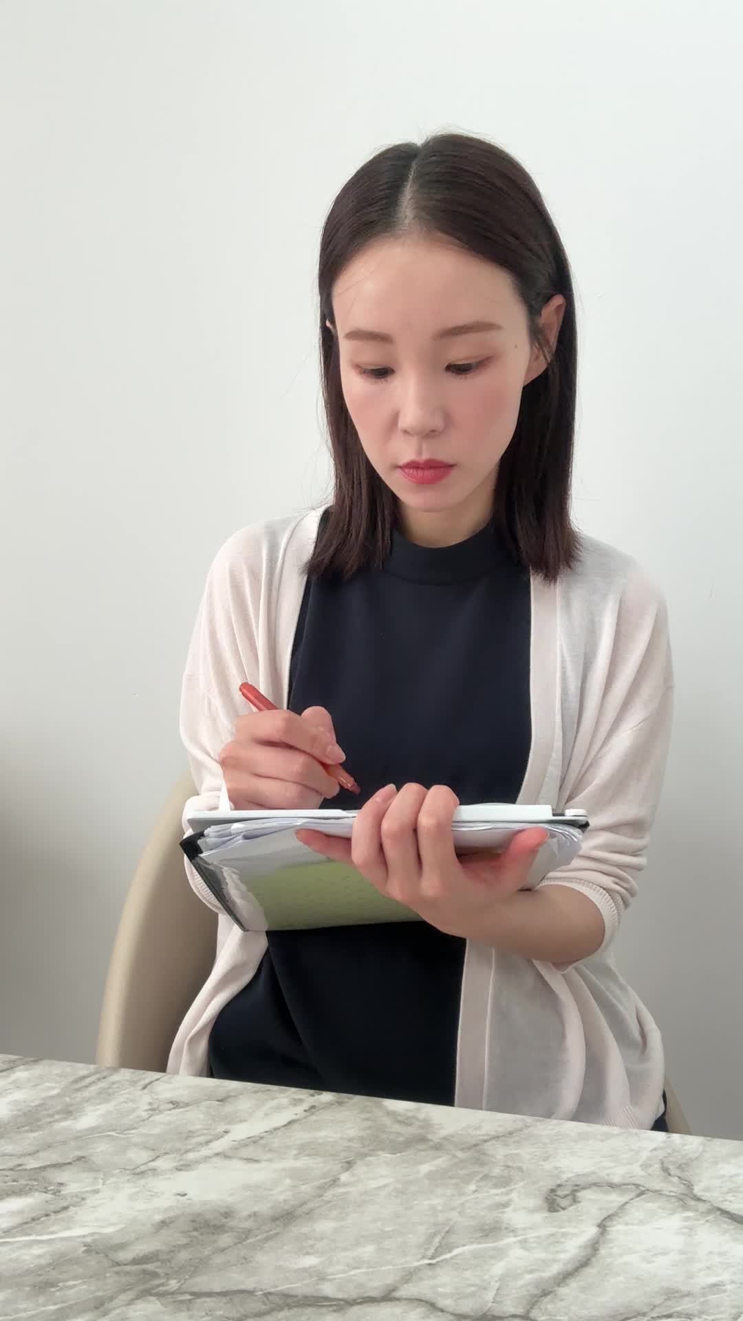 ペンを使い、資料にマーカーで「重要な部分」を印をつける動作