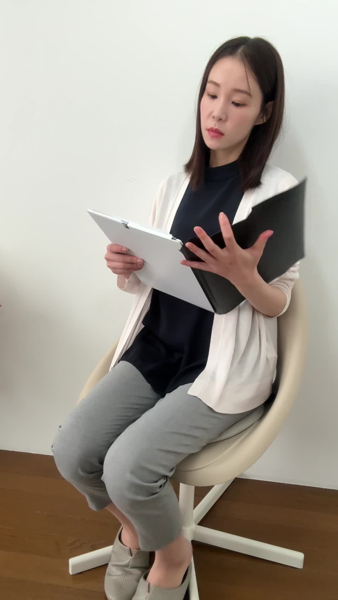 椅子に座り直し、「どれが一番安心できるプラン？」と悩む顔を見せる動作