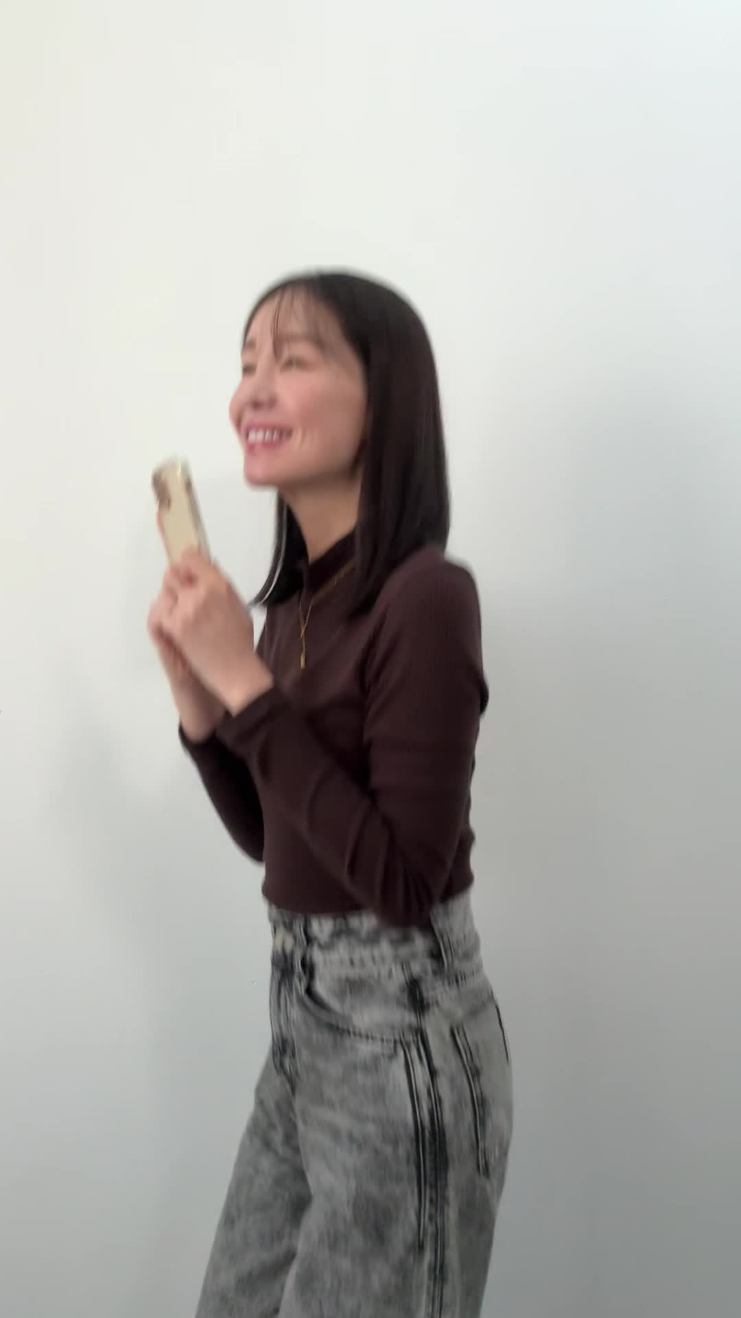 スマホを両手で掲げ、「これだ！」と嬉しそうに跳ねる仕草