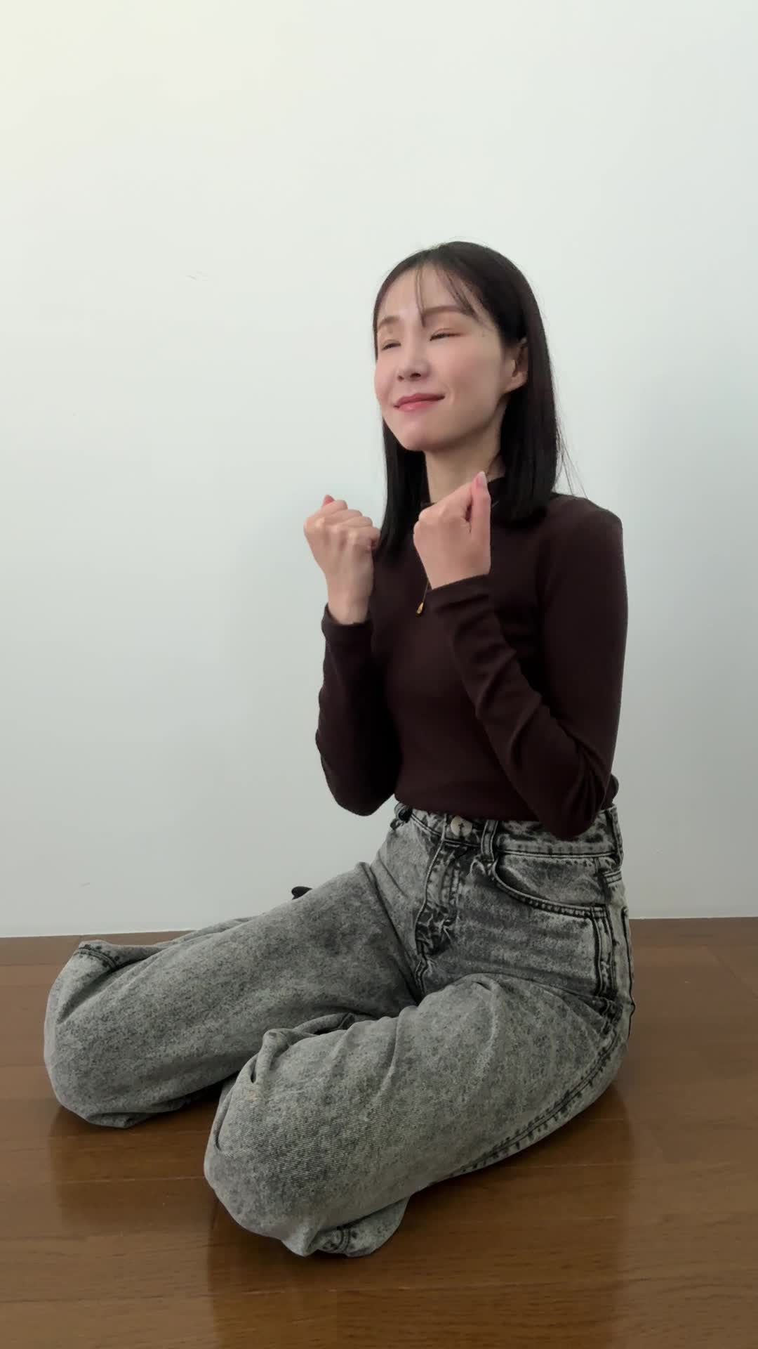 床に横座りして、「副業の道、見えた！」と笑顔を浮かべる動作