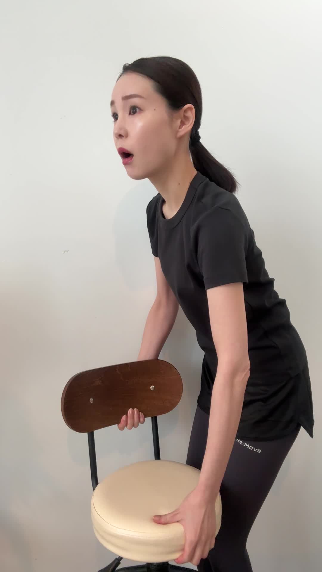 椅子を持ち上げようとして「思ったより重い…！」と驚く表情