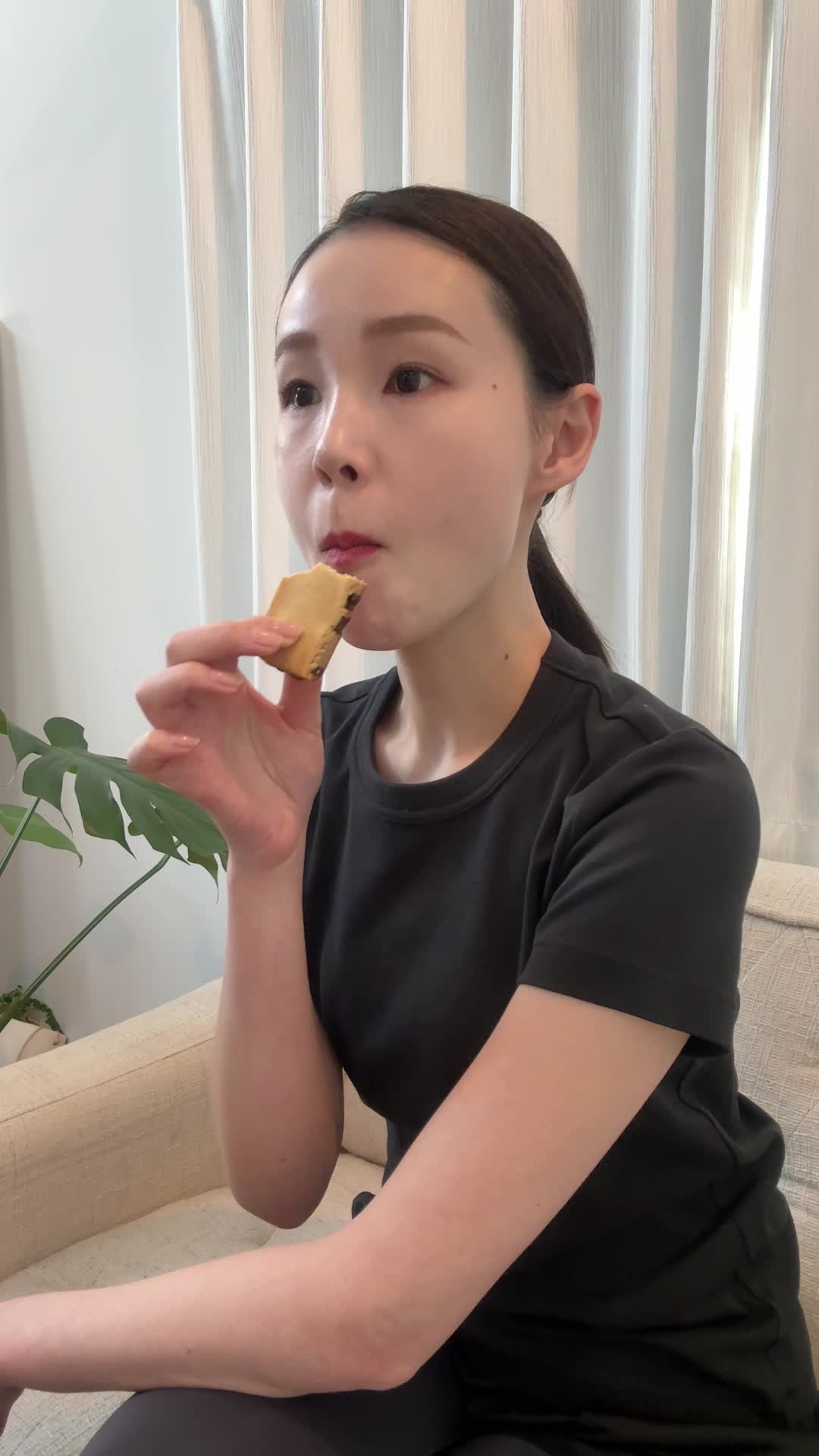 ソファでクッキーを片手に持ちながら、「明日から本気出す」と笑顔を見せる動作