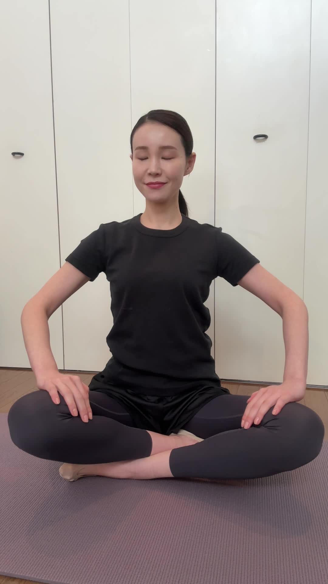 ヨガマットの上で座禅を組み、「まずは心を整えよう」と真剣な表情を見せる