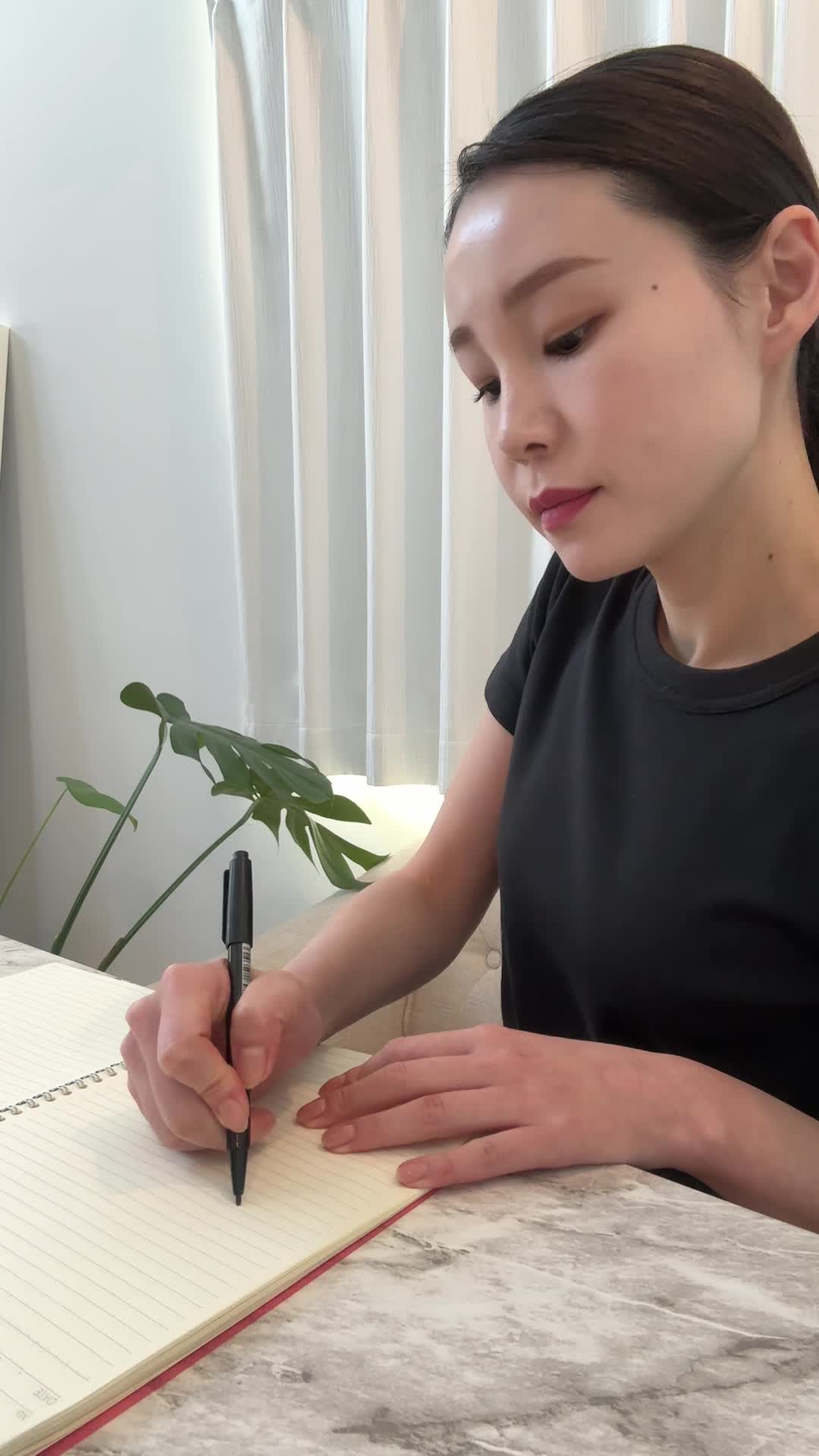 テーブルでノートに「-5kg」と書いてガッツポーズをする様子