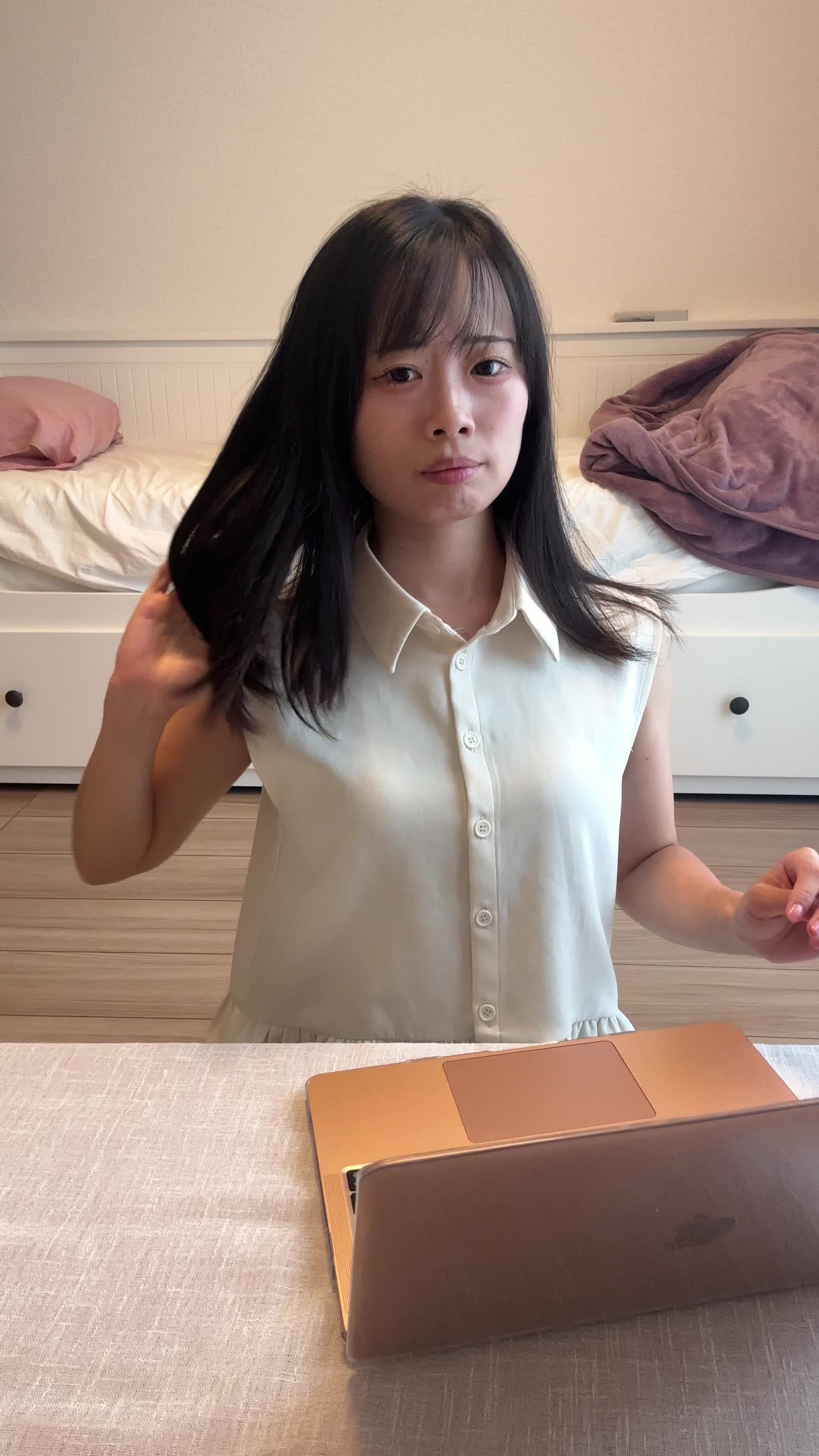 椅子に座り、仕事中に髪のパサつきが気になり、少しイライラする表情を見せる姿