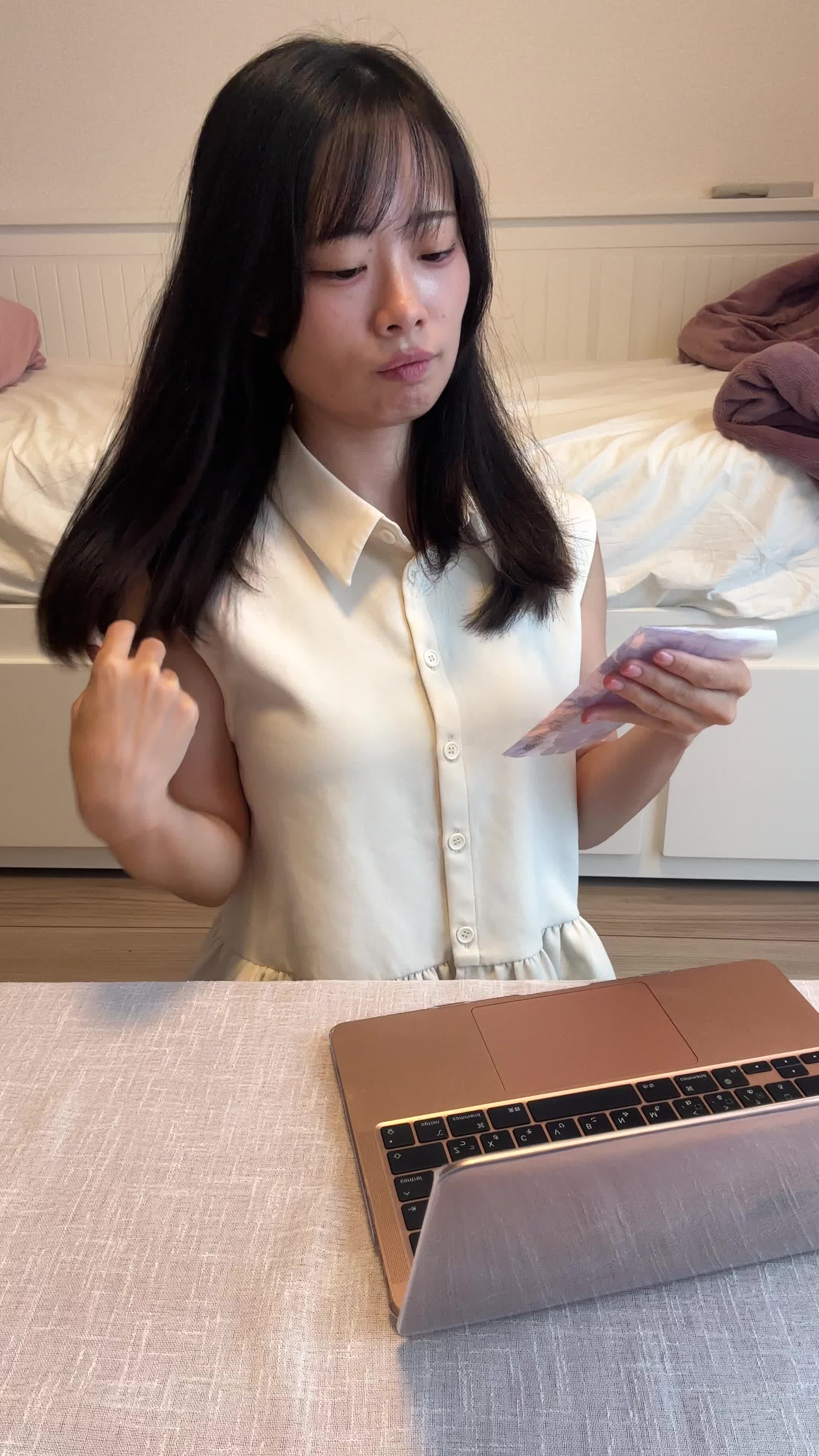 椅子に浅く腰掛け、髪を手ぐしで整えながら「このシャンプー試してみよう」と決意する表情