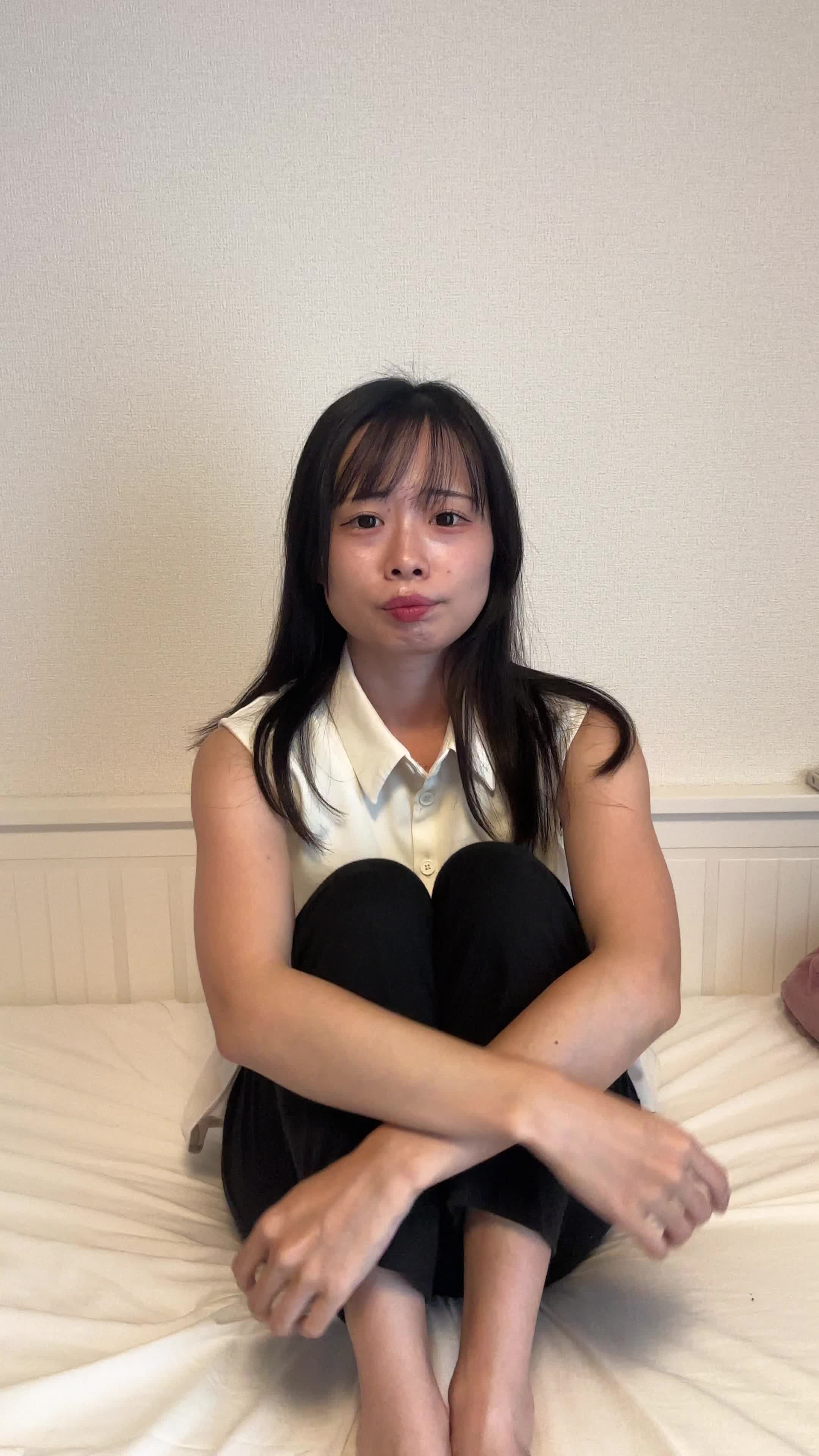 ソファで膝を抱え、「次の週末には髪をツヤツヤにしたい」と考え込む表情