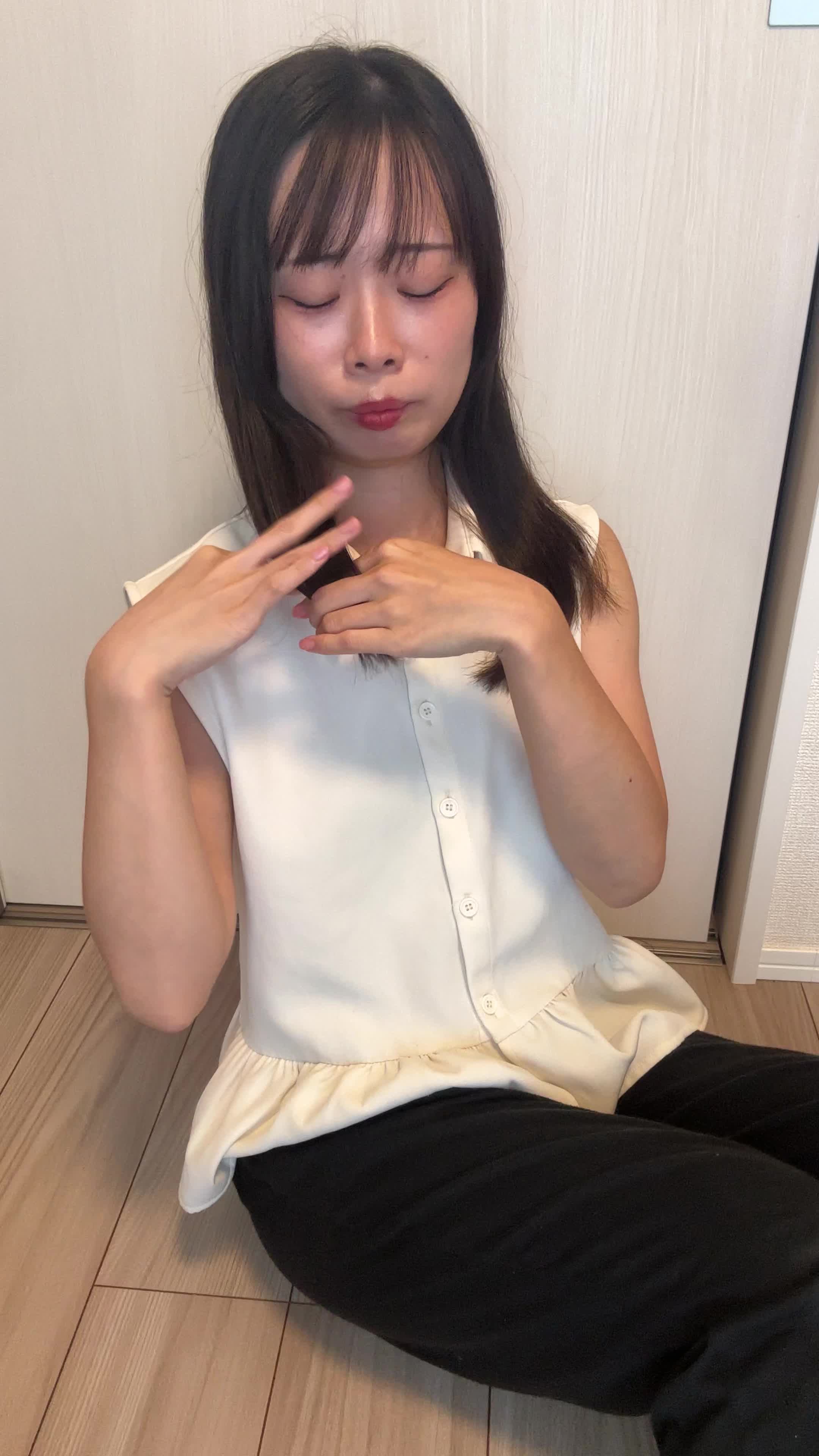 床に座り込み、髪のうねりを手で押さえ、「これじゃ外に出られない」と悩む様子