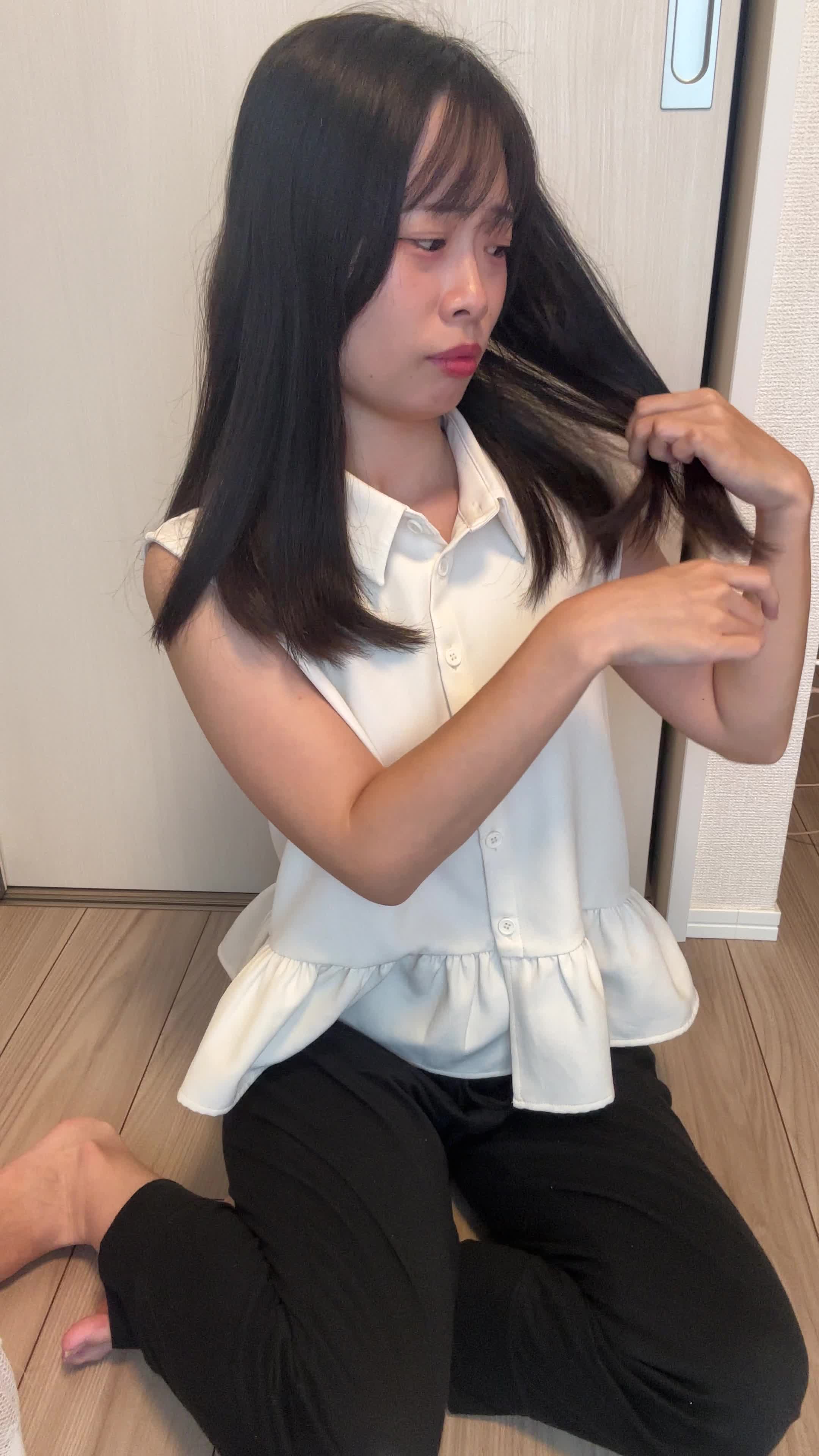 床に座り込み、髪の毛先を見ながら「これじゃデートに行けない」と焦る動作