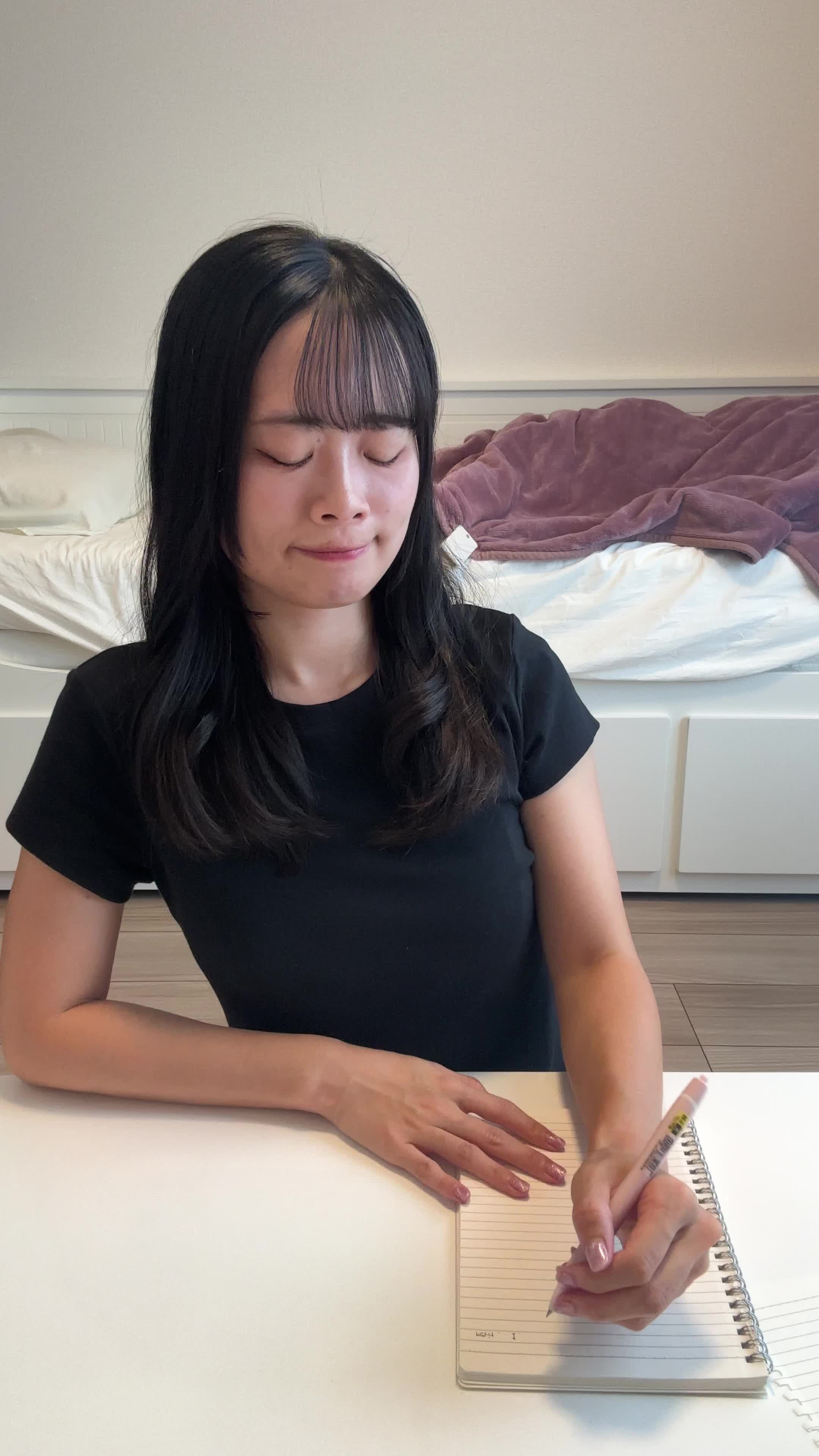 椅子に腰掛け、紙にウォーターサーバーのメリットを書き出している様子