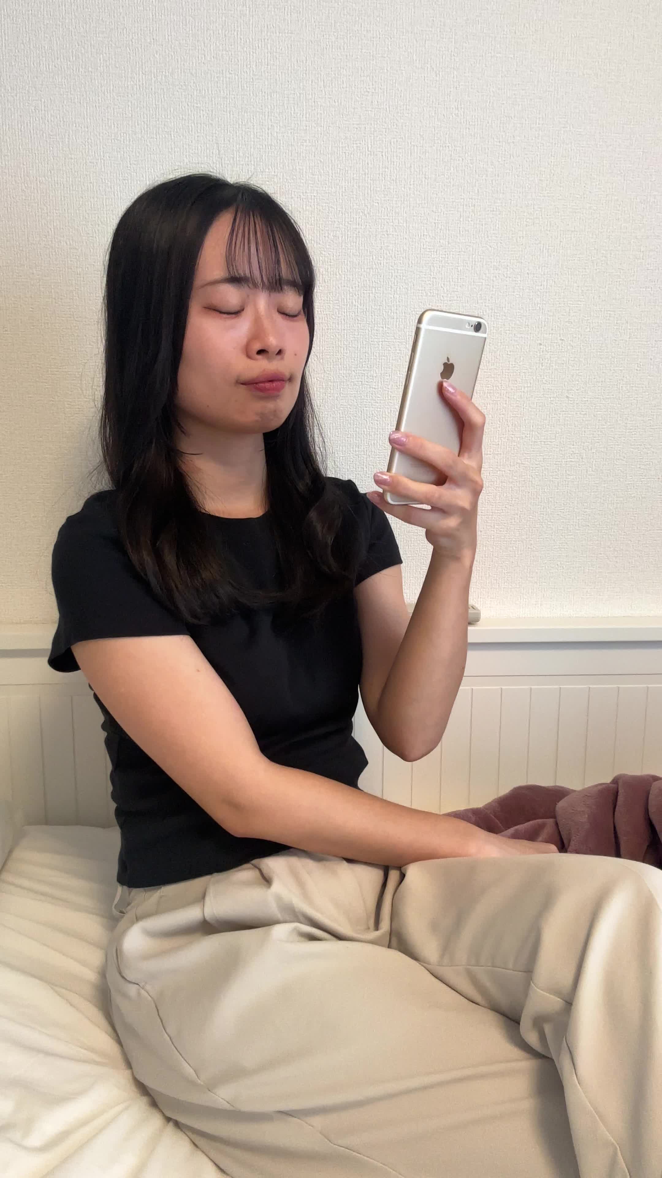 ベッドでスマホを見ながら、「ウォーターサーバーってどうなんだろう？」と検索する様子