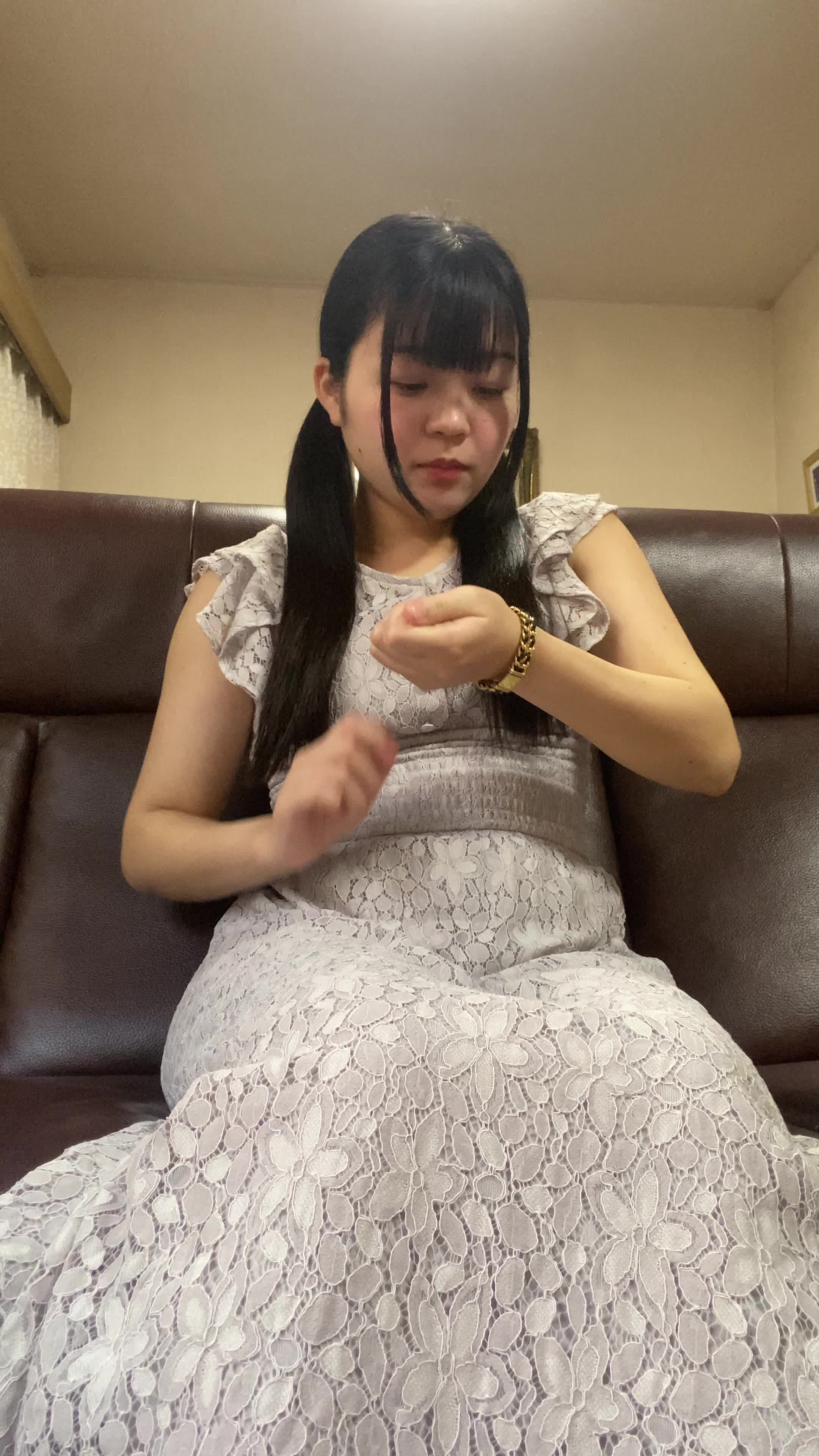 ソファで時計を見ながら、「次の配信時間まであと少し！」と期待で胸を膨らませる表情