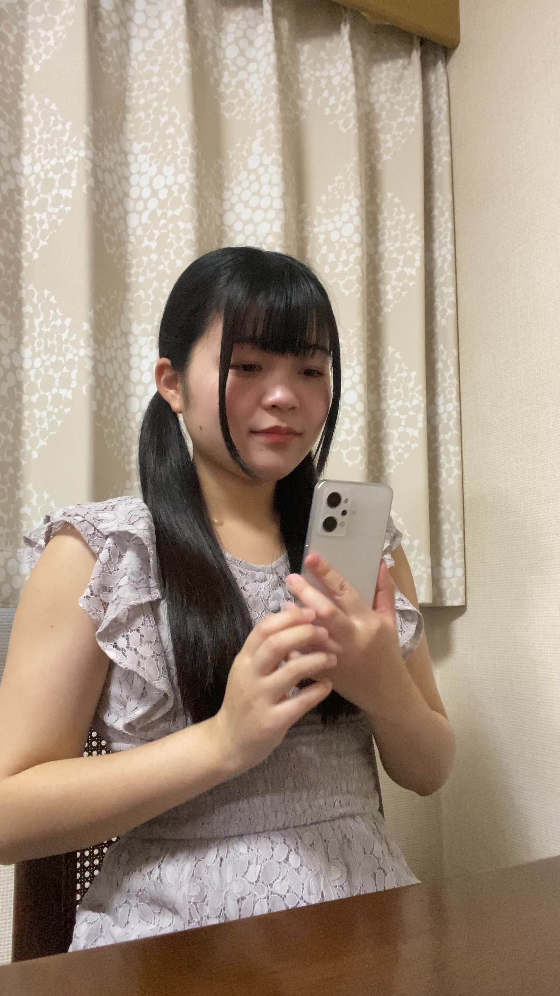 椅子に腰掛け、スマホを置いて「早く観たい！」と小さくガッツポーズをする仕草