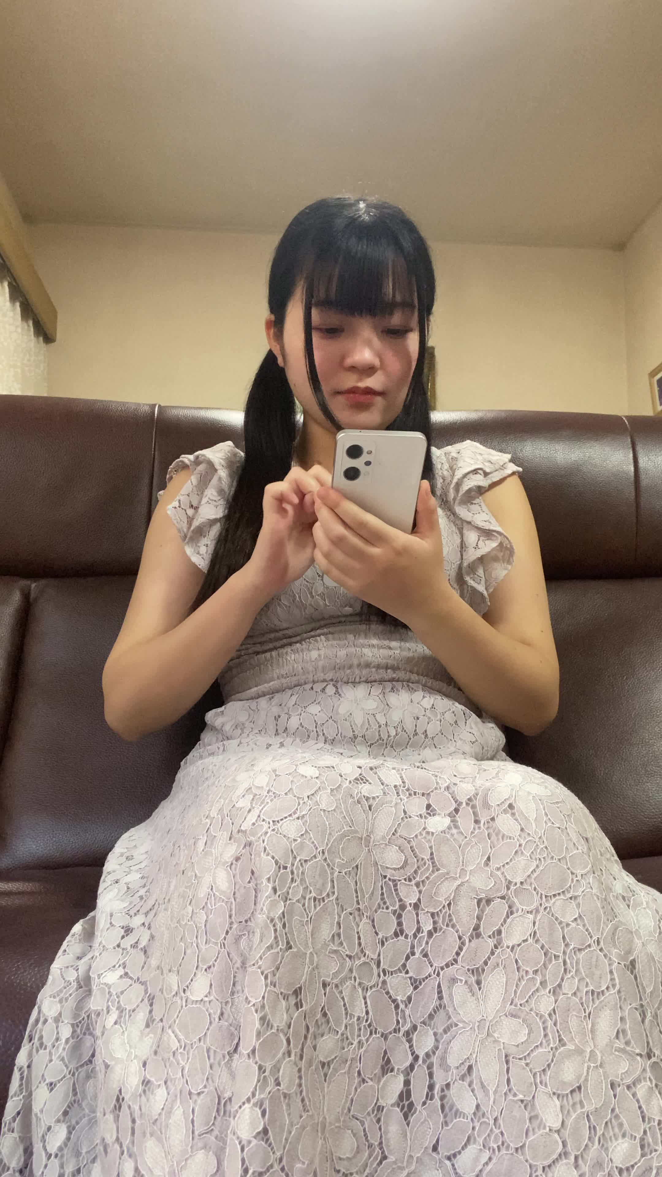 ソファでスマホを操作しながら、「次の休憩時間までに何を観るか選ぼう」と考える様子