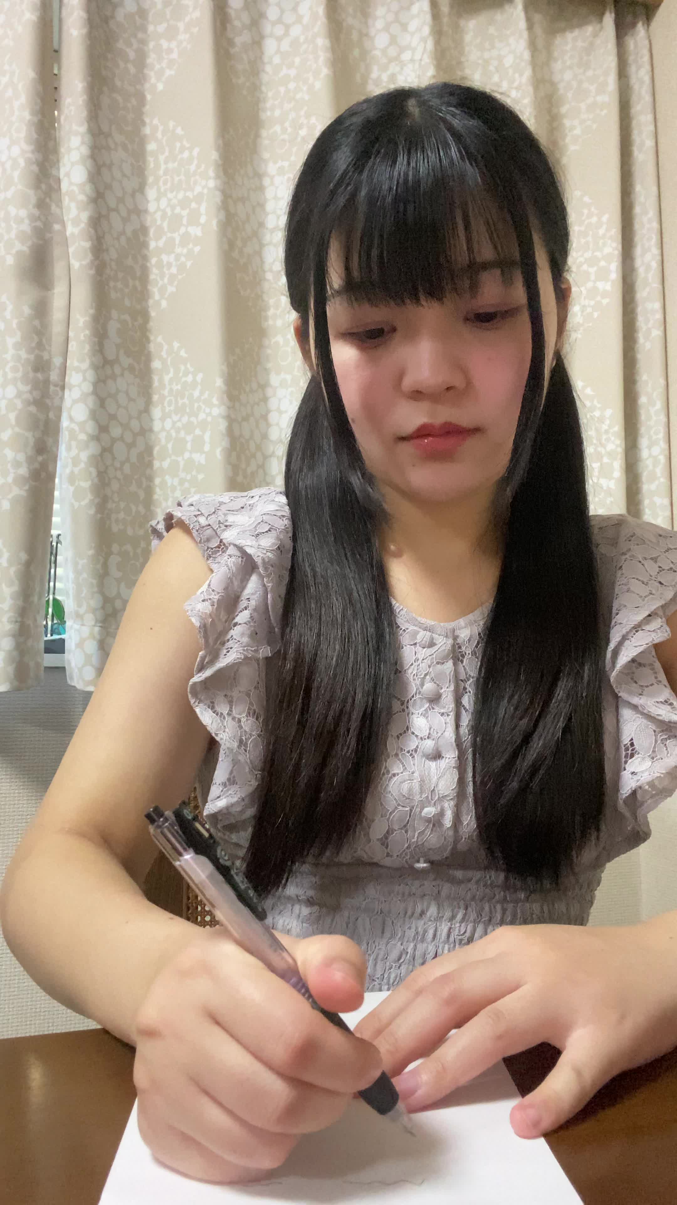 テーブルでペンを置き、「やっと終わった！見よう！」と笑顔になる動作