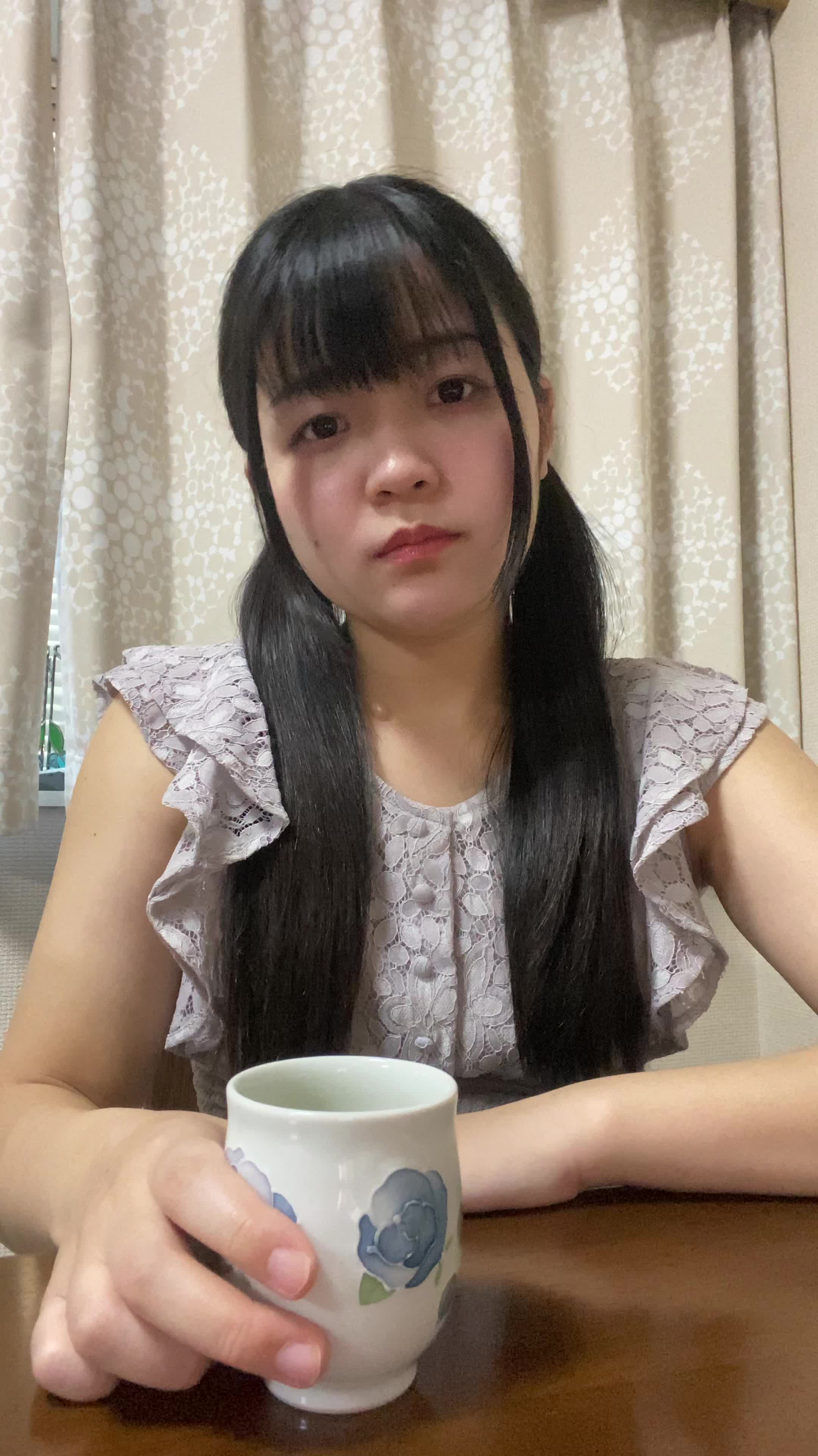 テーブルでコップを手に、「観たい作品が多すぎて迷う」と真剣に考える動作