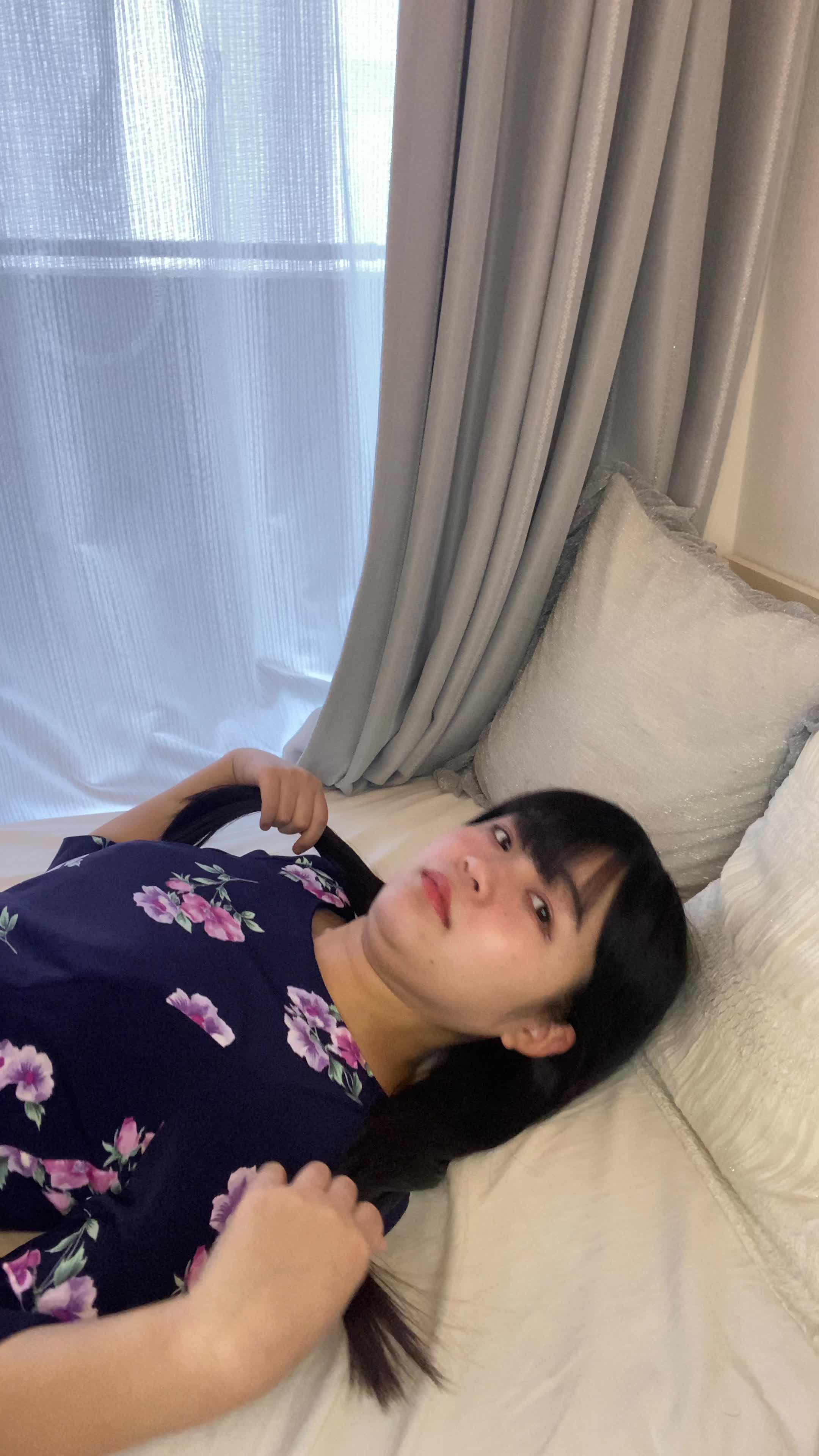 ベッドで横になり、「笑顔がもっと綺麗になるのかな？」と微笑む様子