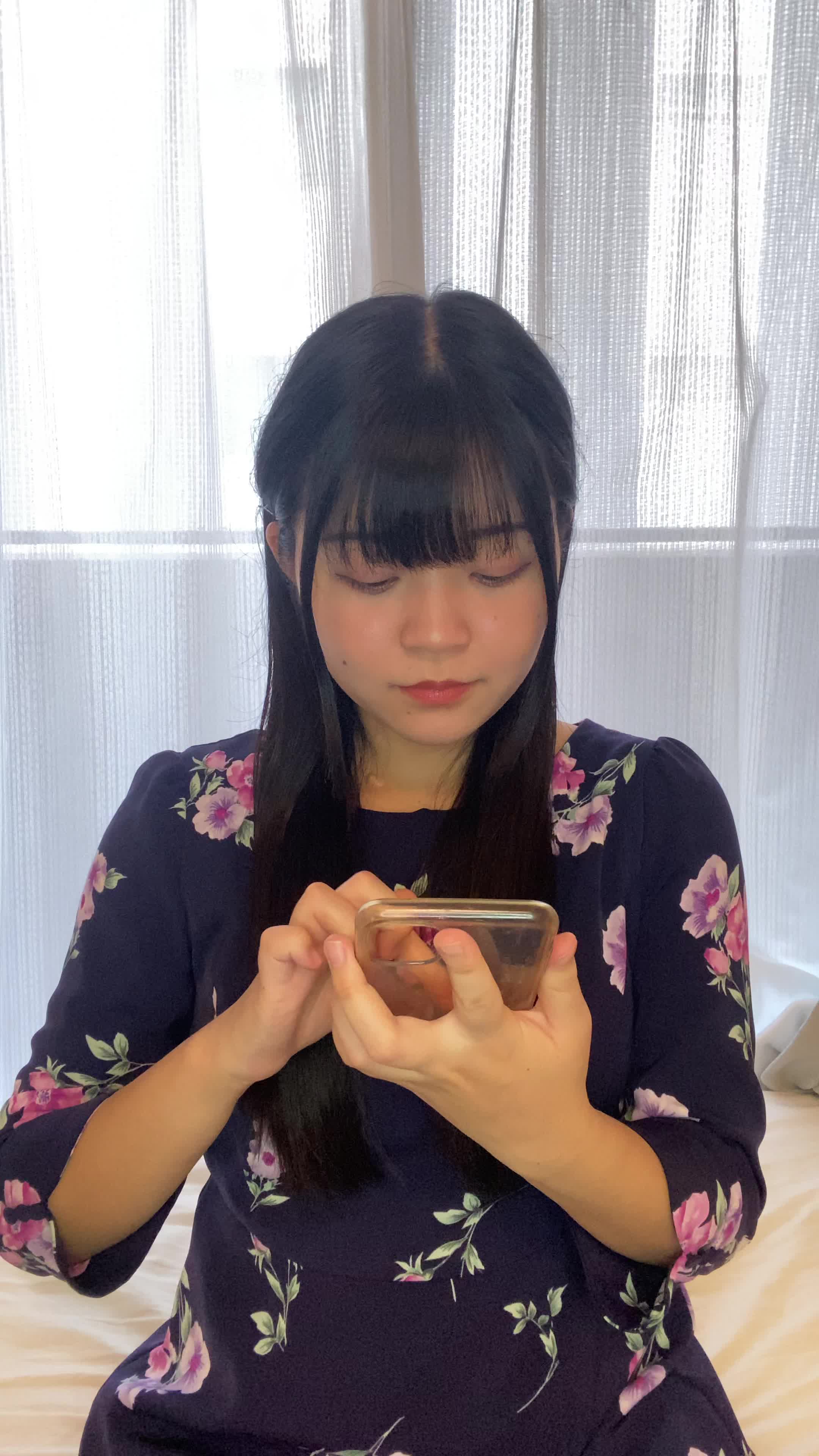 ソファでスマホを見ながら、「矯正の口コミ」を調べて頷く様子