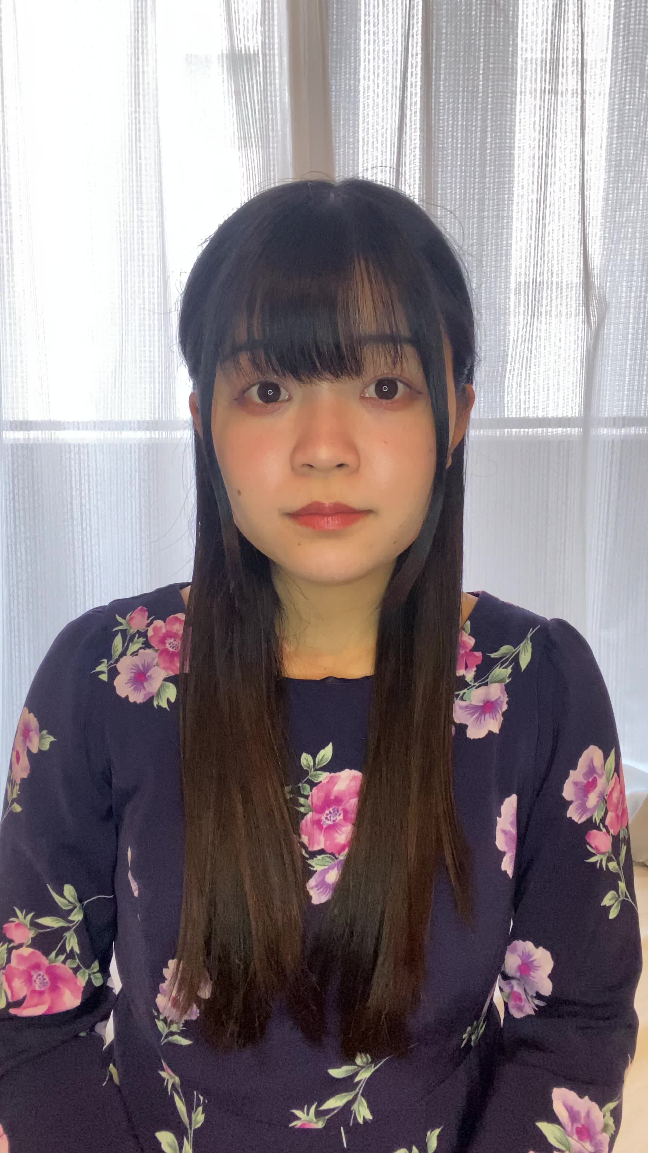 ソファで友達と話しながら、「自分の歯並びが気になる」と口元を隠す仕草